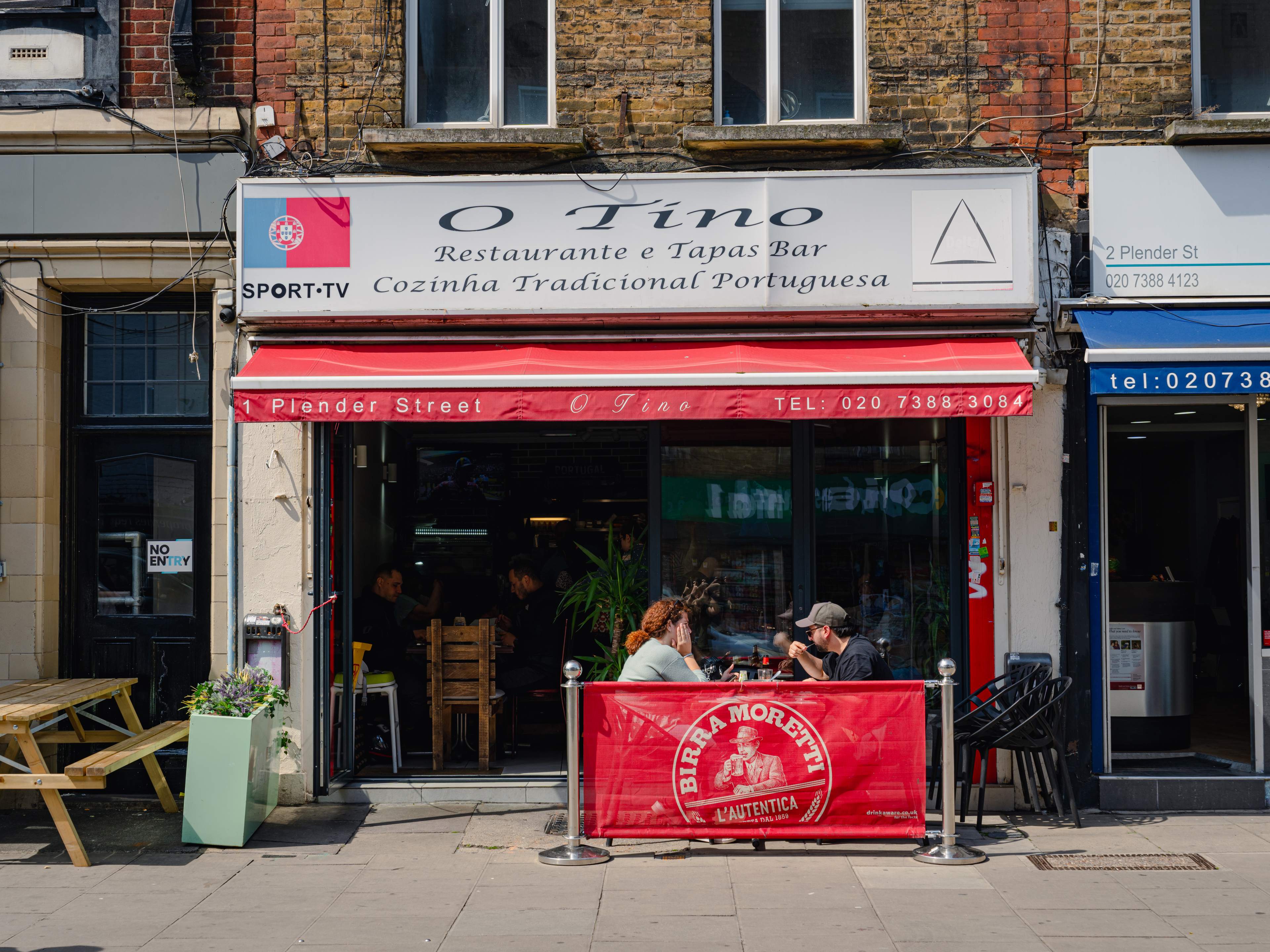 Red and white restaurant exterior, with the words 'O Tino'.