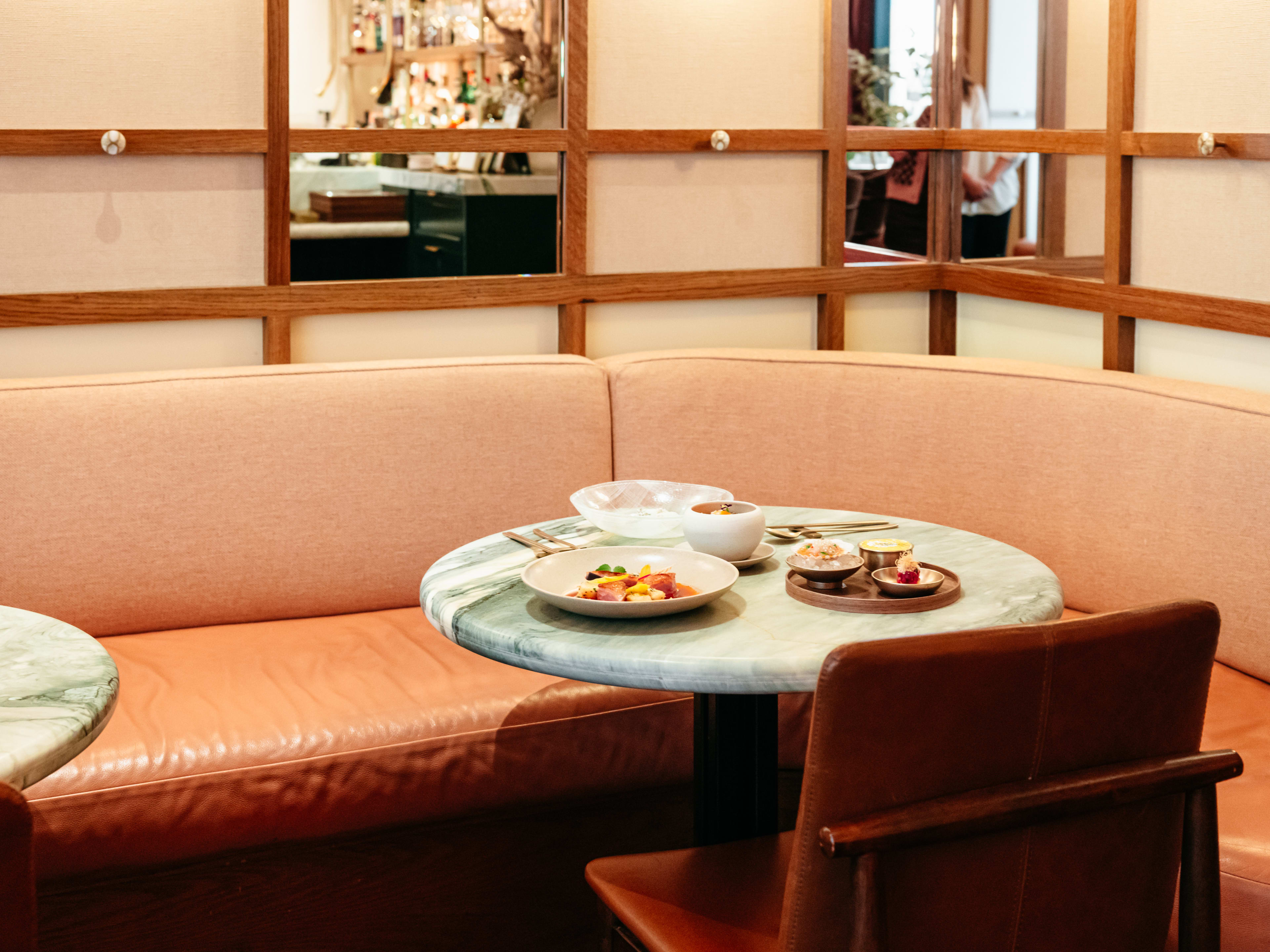 A pink couch and table with food.