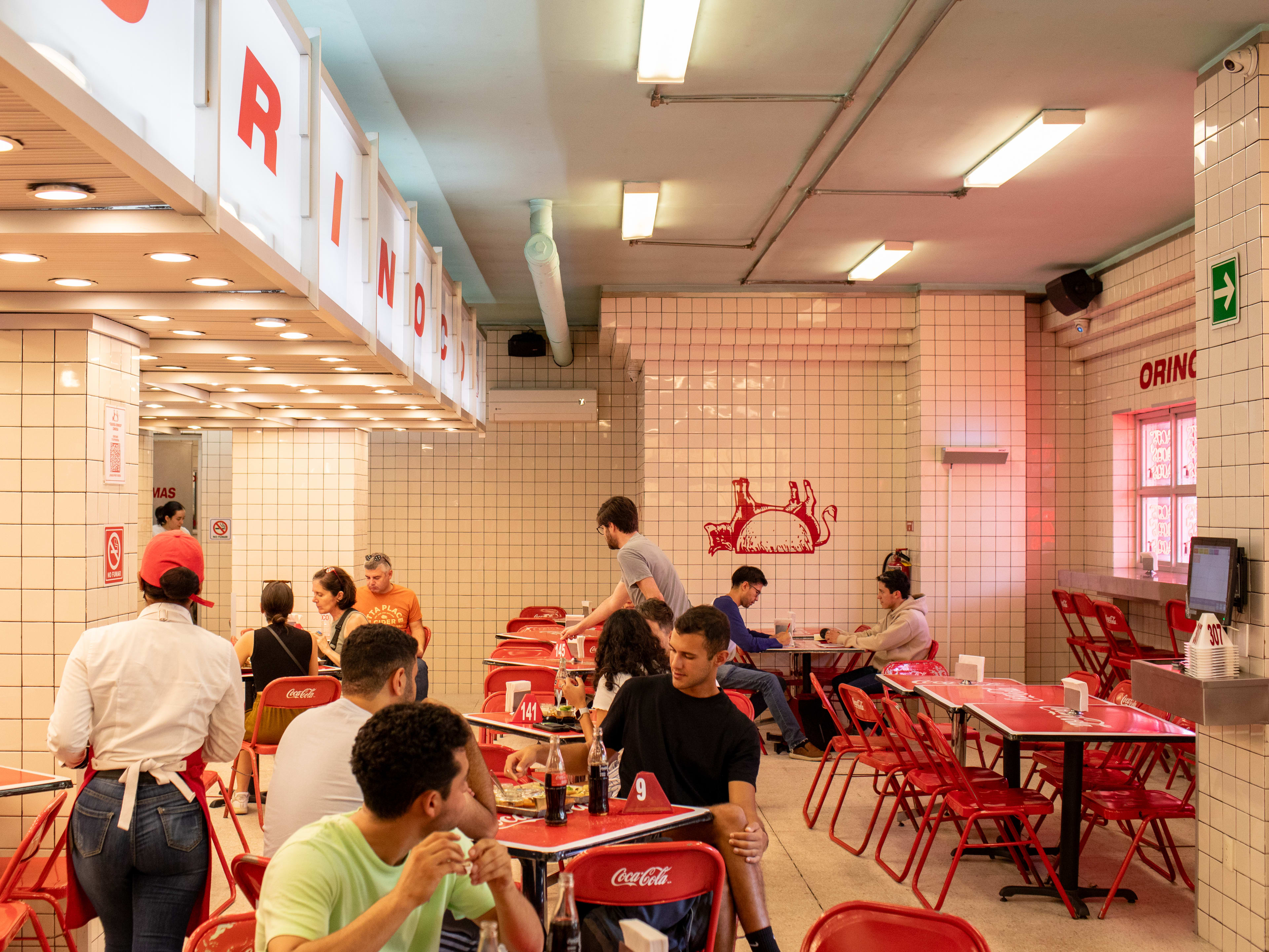 People sitting at casual tables inside Taqueria Orinoco in Mexico City