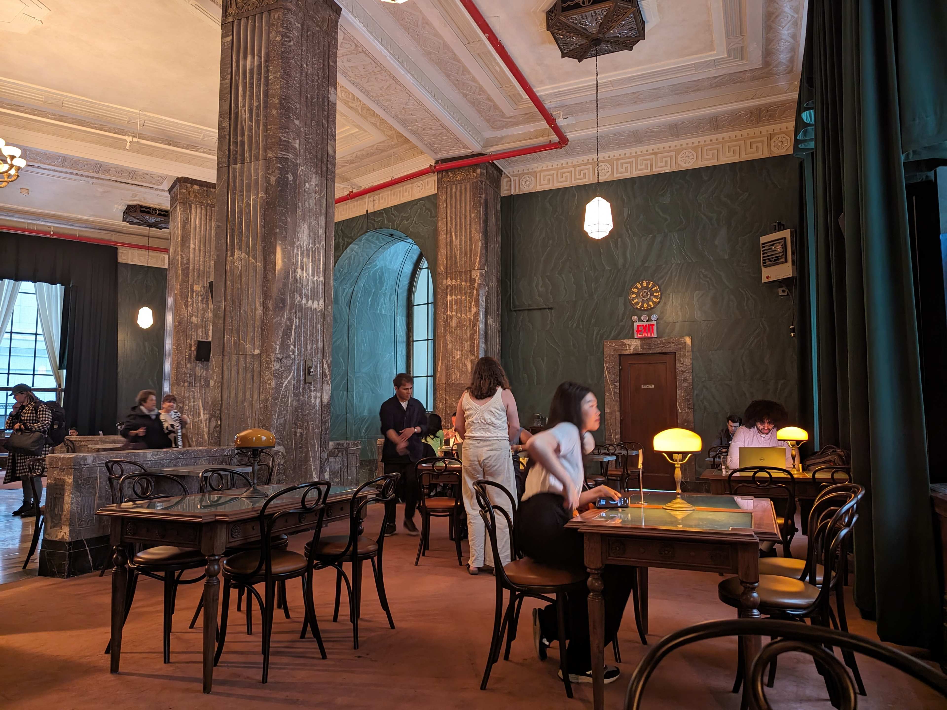 view of the room with green curtains and grey marble columns