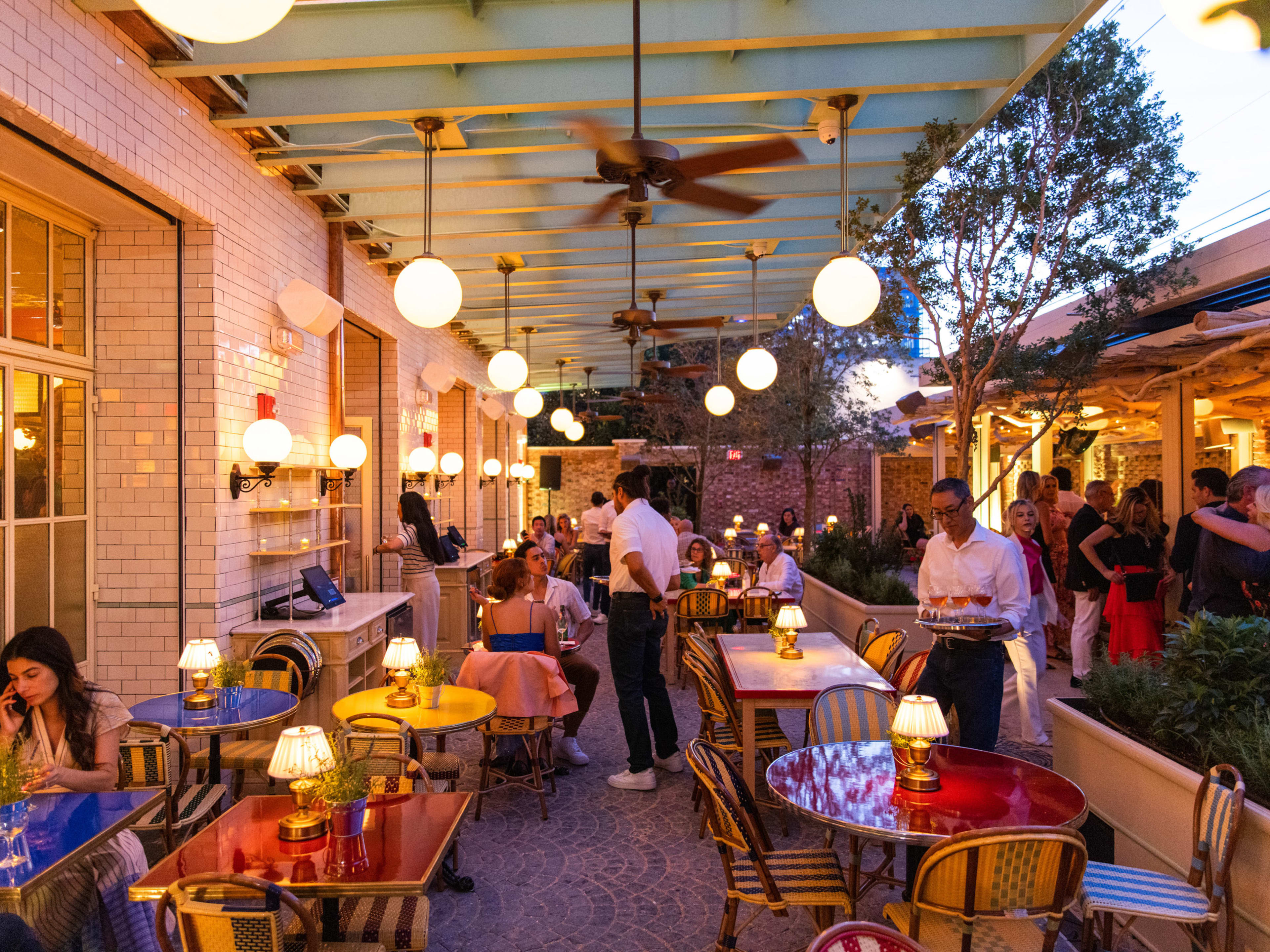 People eating in the outdoor patio of Pastis Miami.