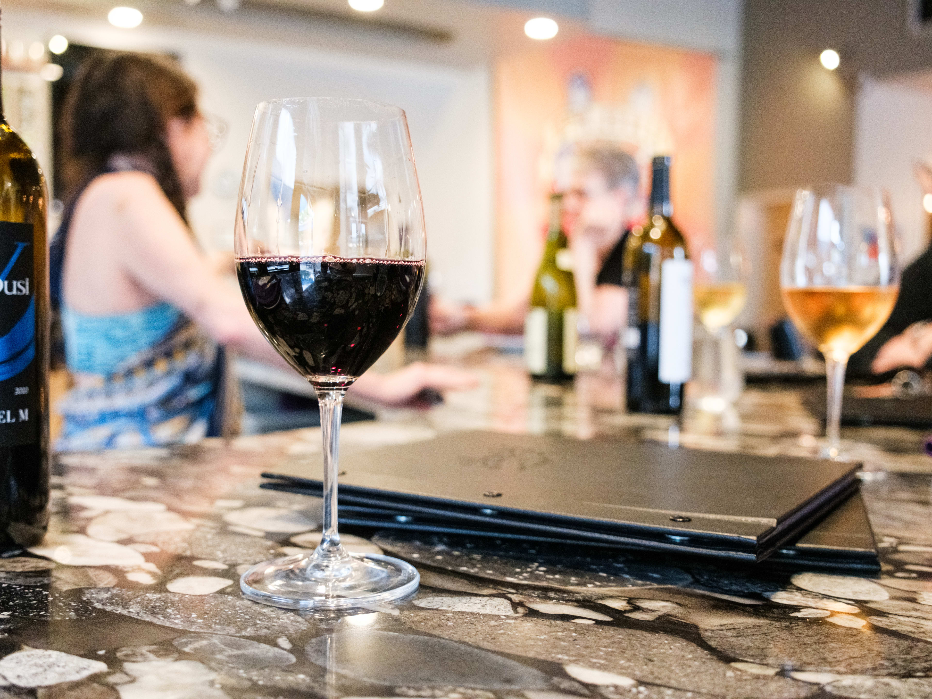 People enjoying wine at the bar at Plonk! Wine Bar & Cellar.