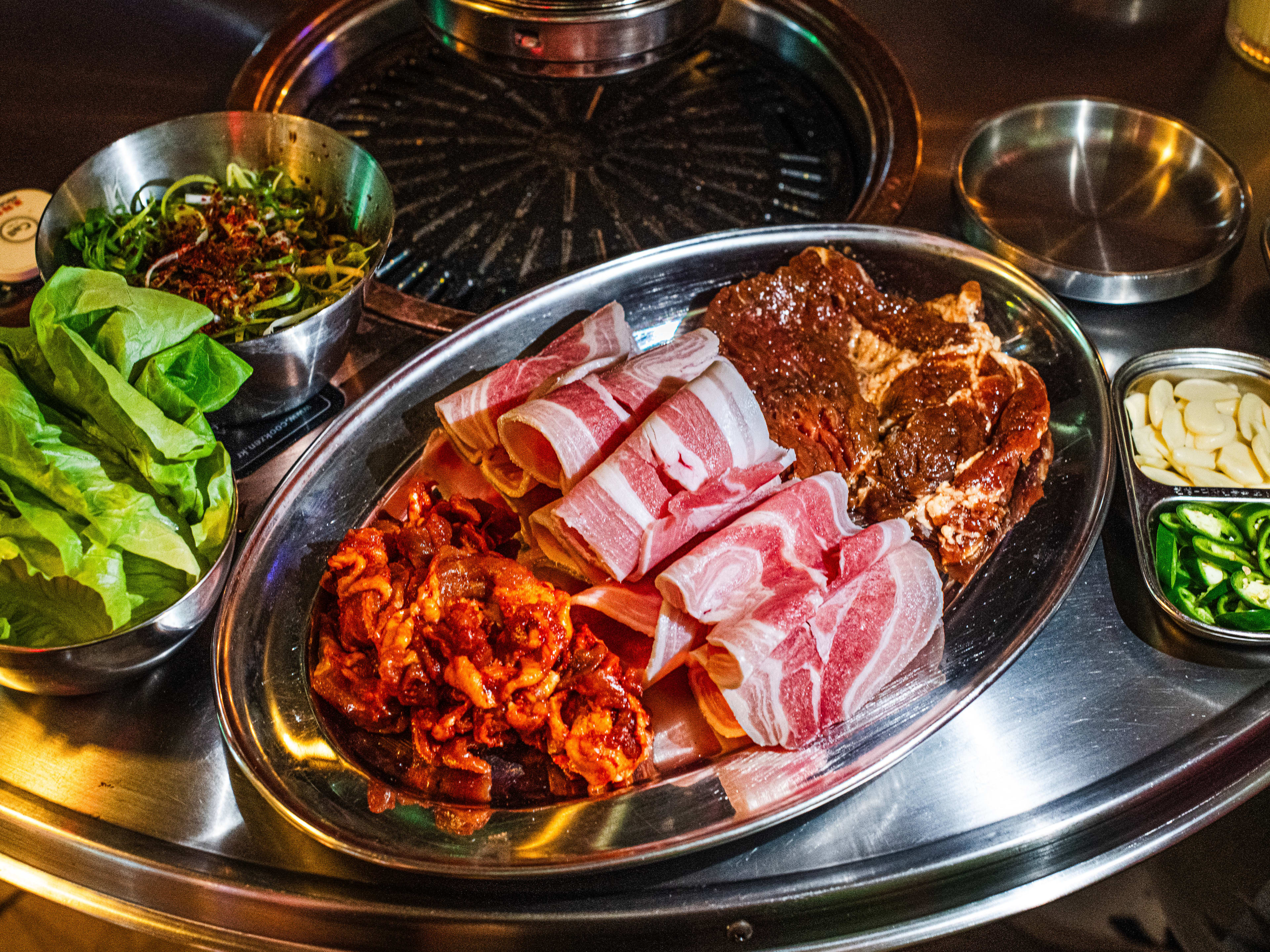 The pork combo BBQ from Pochawa Grill set on a metal table with tabletop grill.