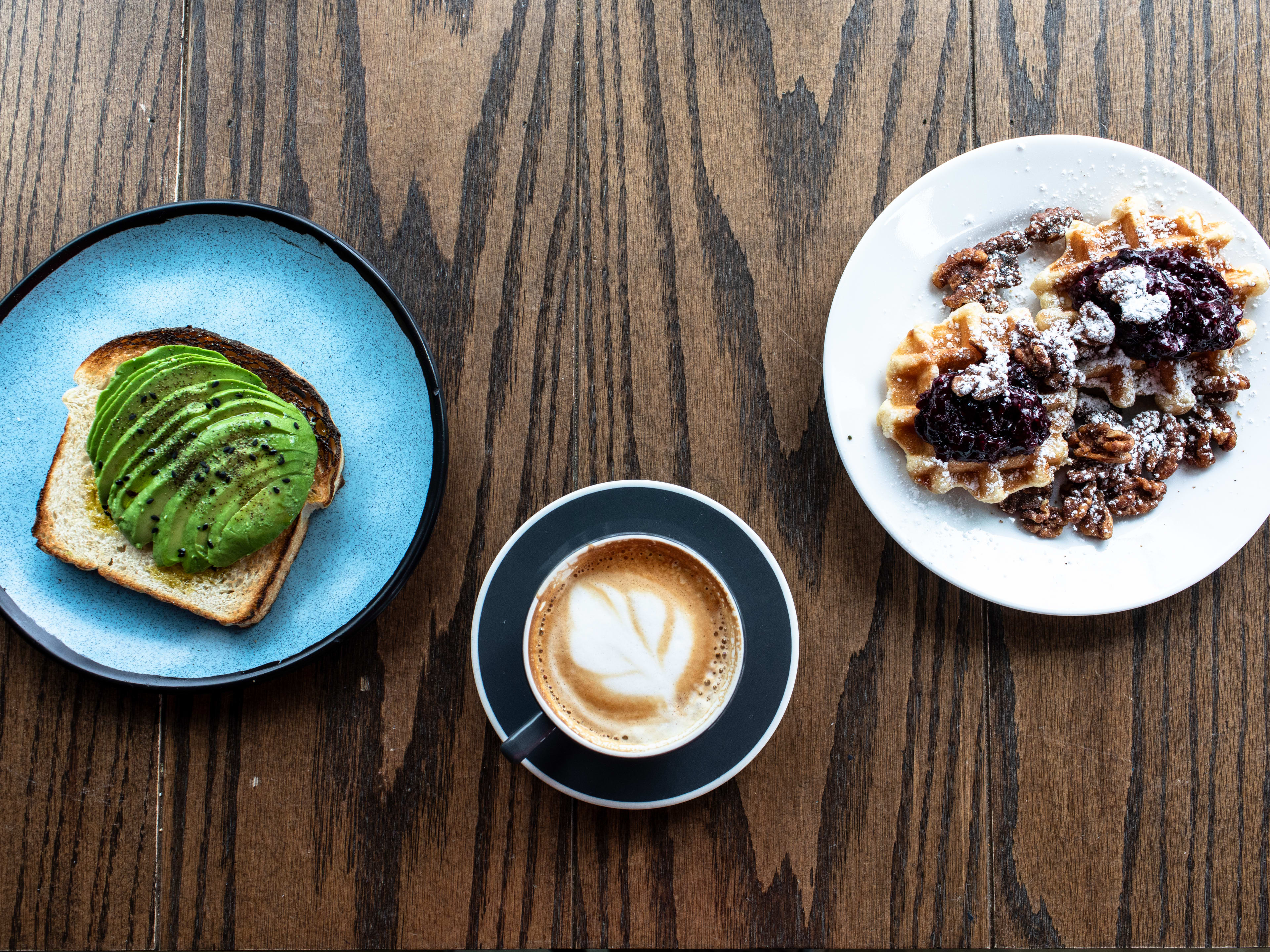 Spread of Avocado Toast, Latte and Waffle dish at Queen City Grounds.