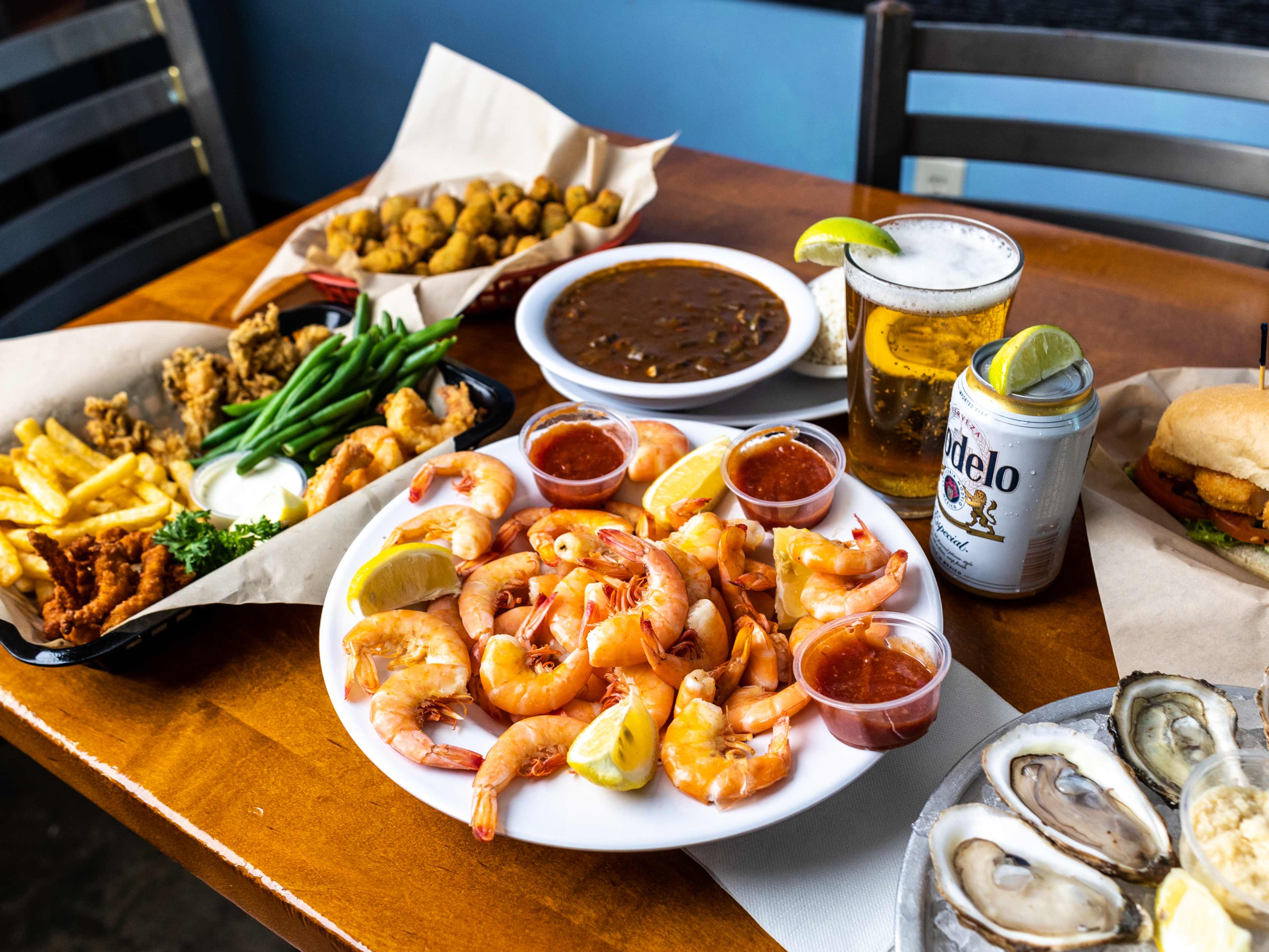 fried seafood, shrimp, oysters, and beer on a table