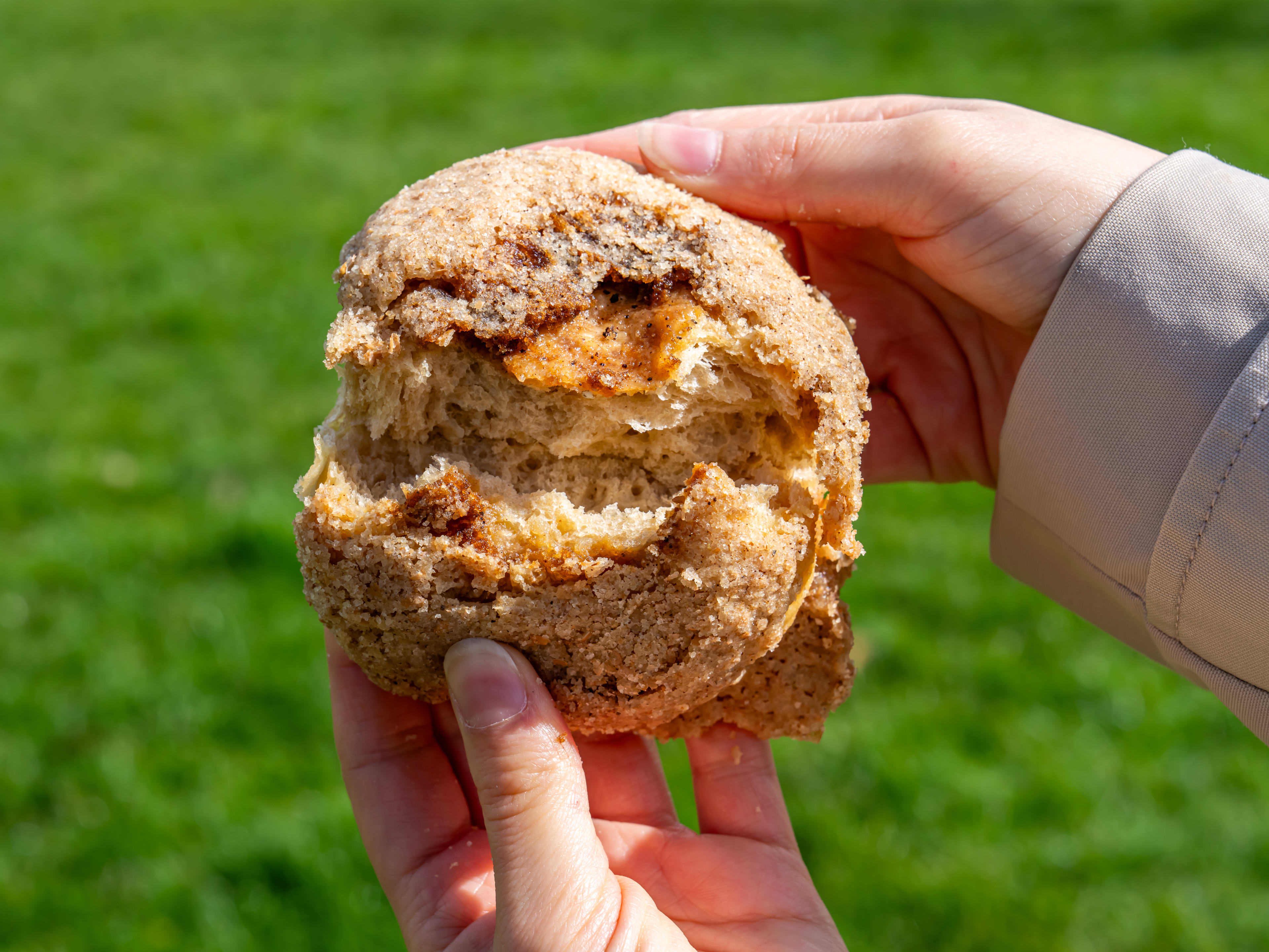 A brown butter bun being ripped in half from Quince Bakery.