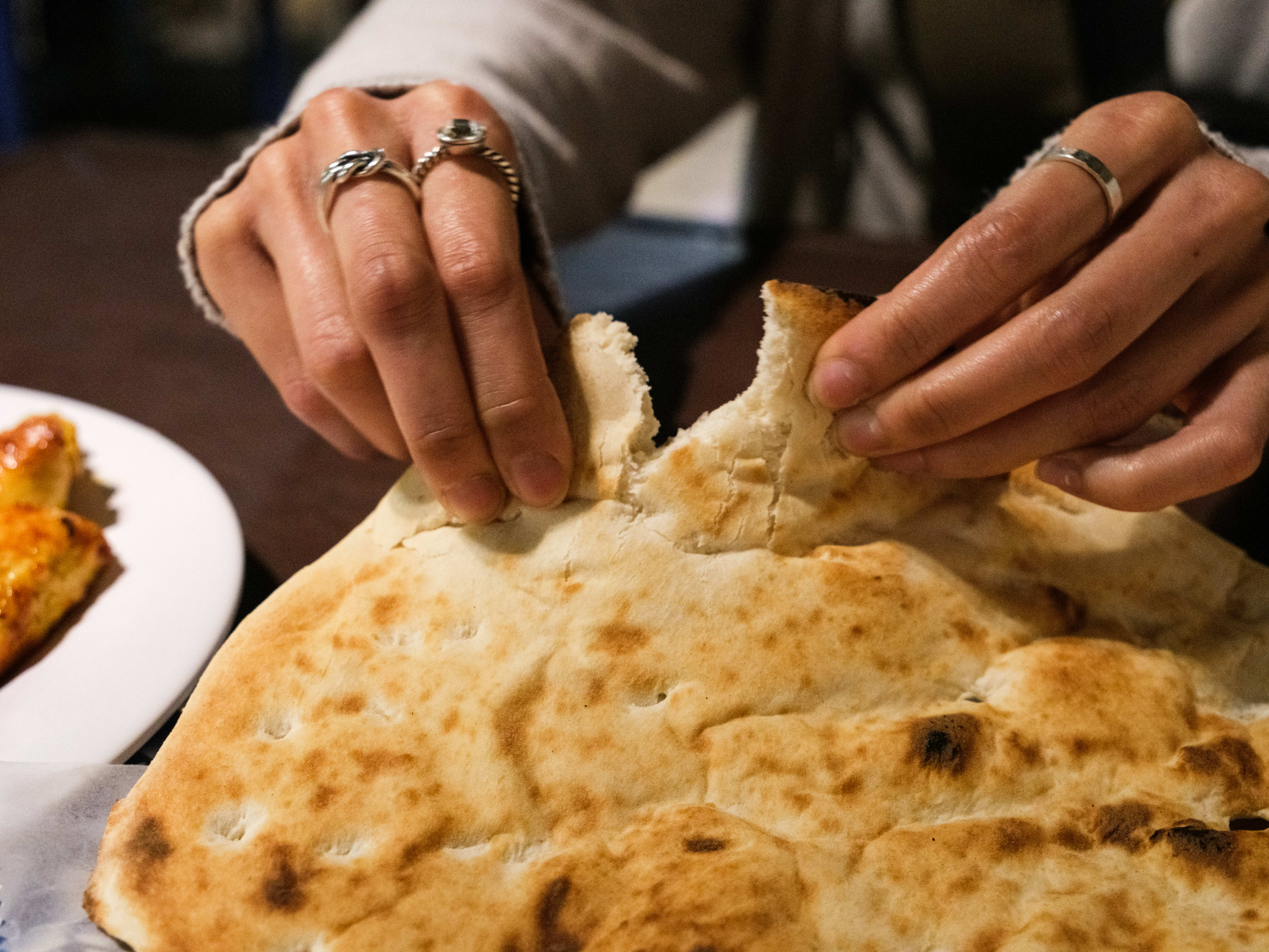 A person pulls apart bread from Ranosh Cafe.