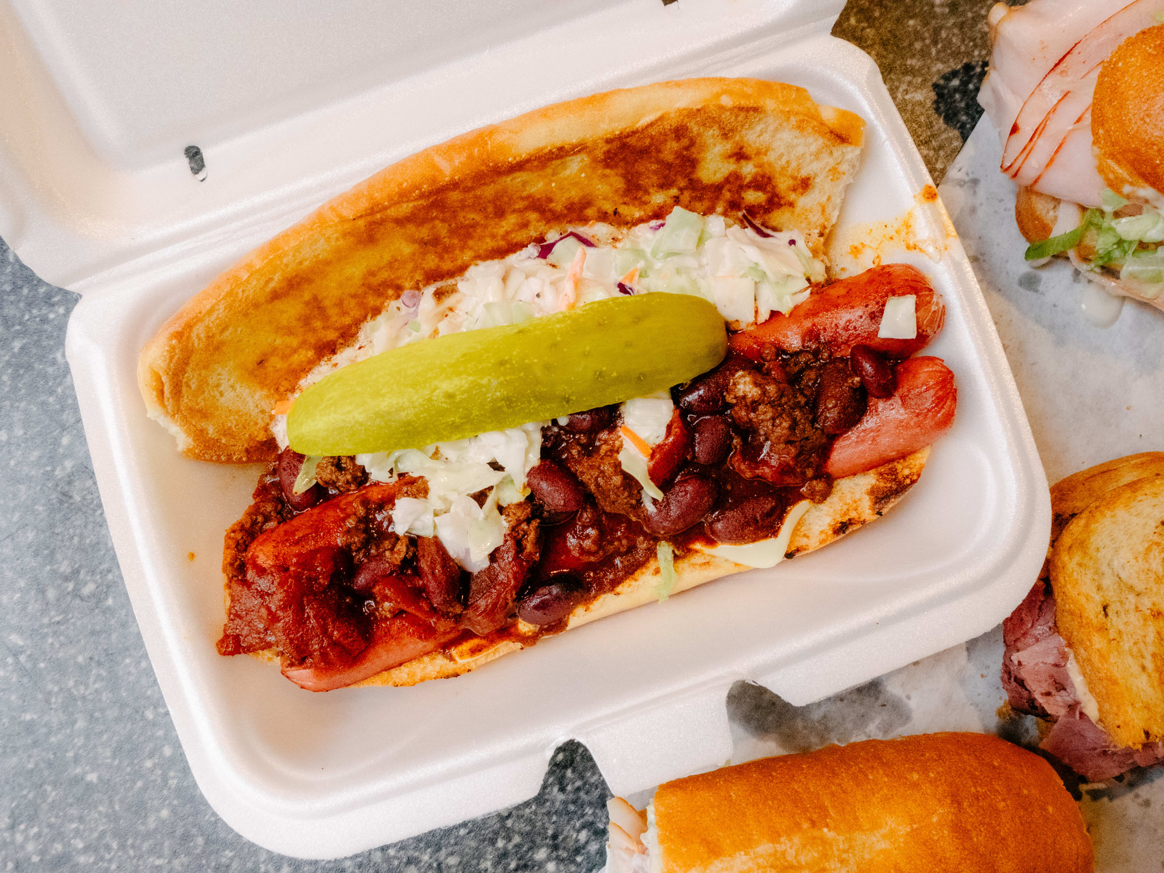 A massive hot dog with cheese, chili, and slaw.