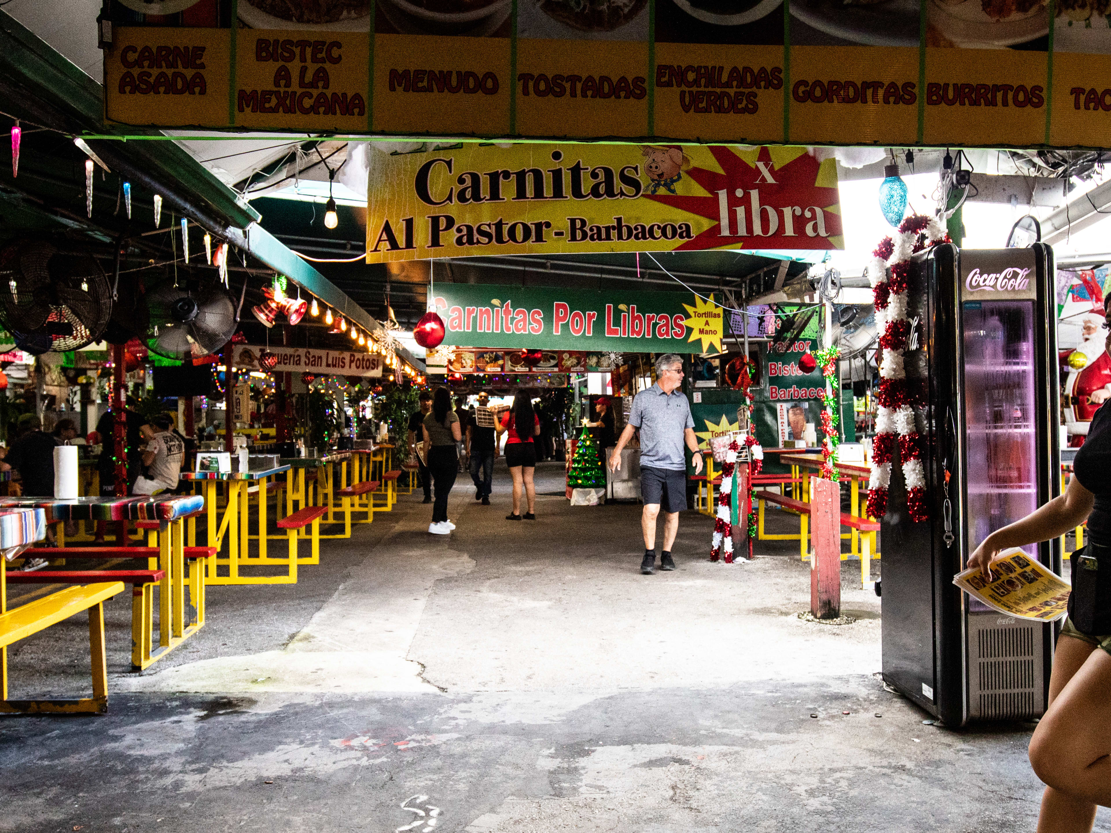 Indoor/outdoor market with colorful banners advertising Mexican food.