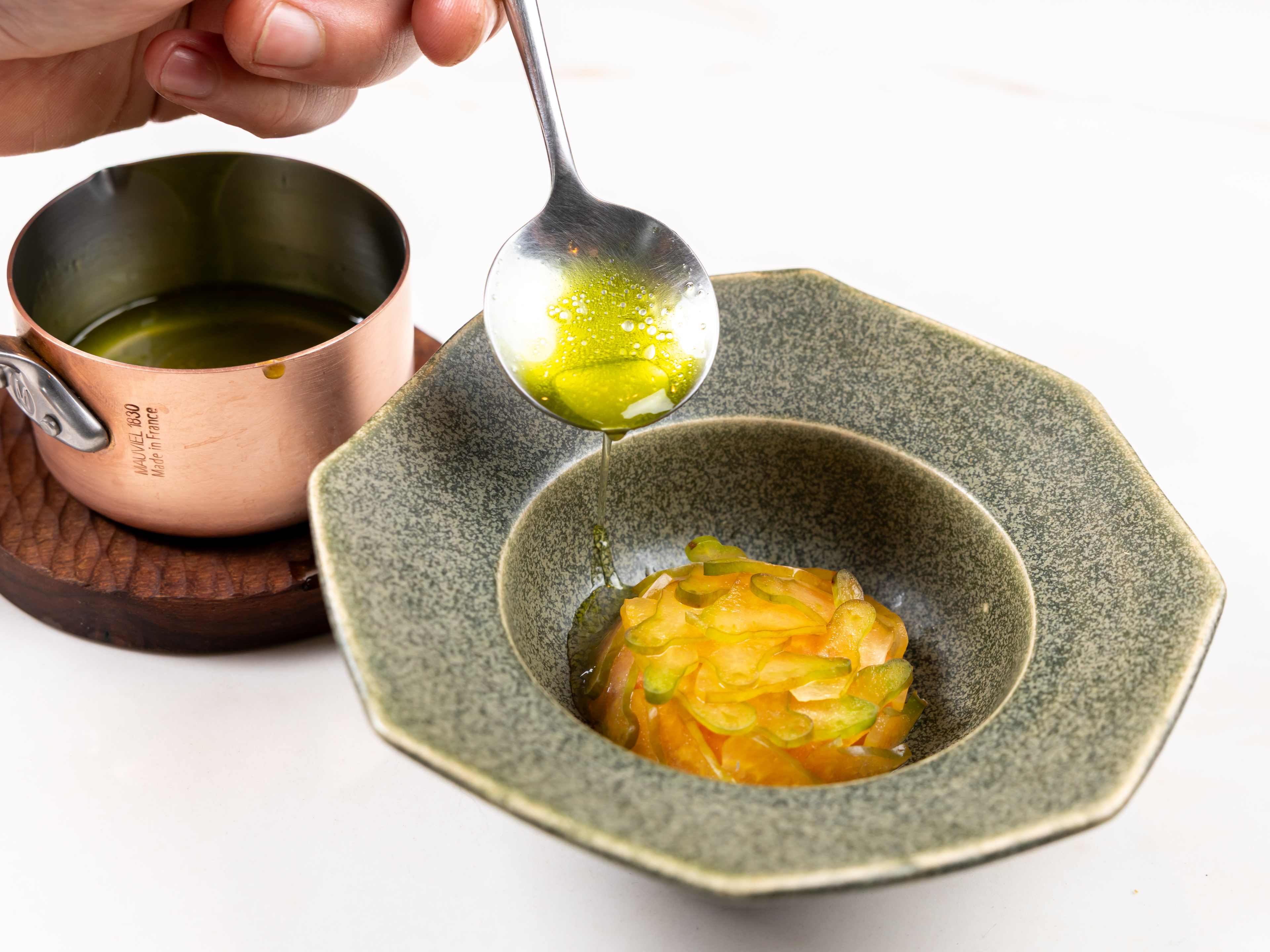 raw fish kinilow with sauce being spooned over from small pot at Restaurant Naides in San Francisco