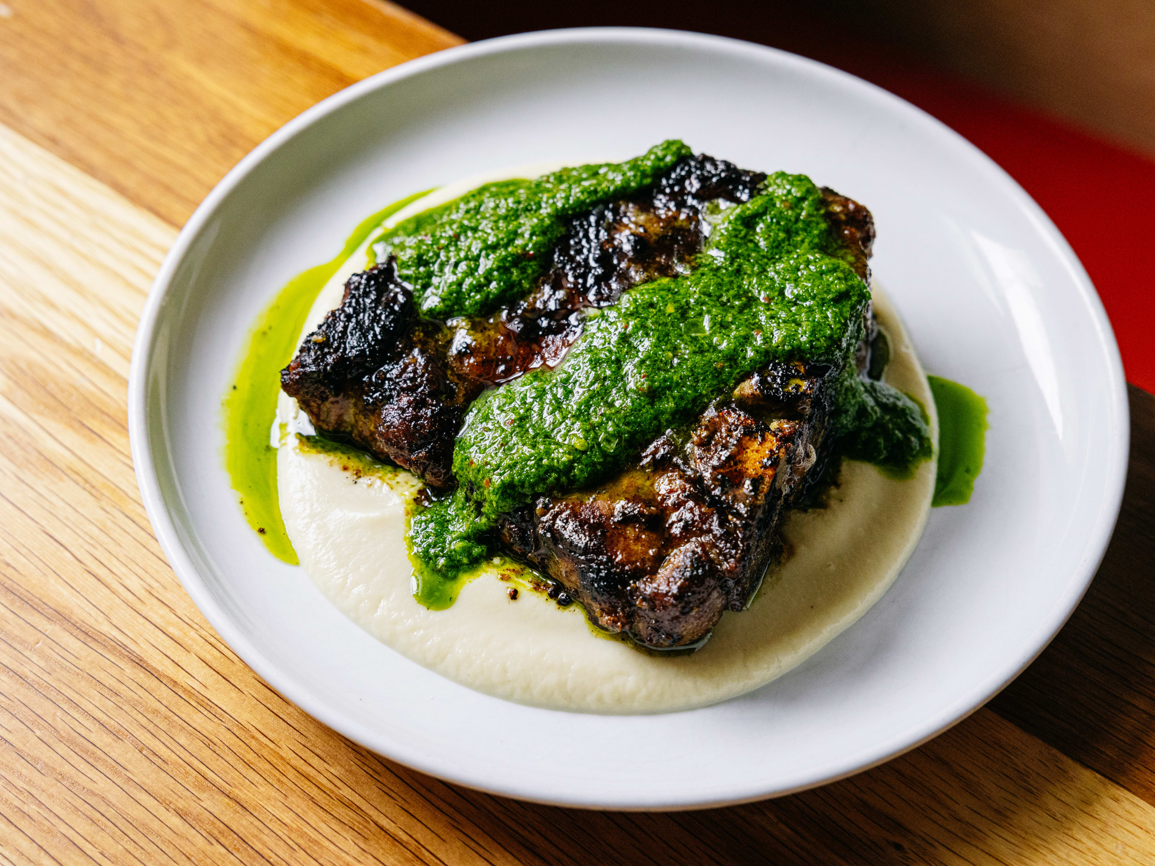 a grilled pork t bone with salsa verde and a celeriac puree