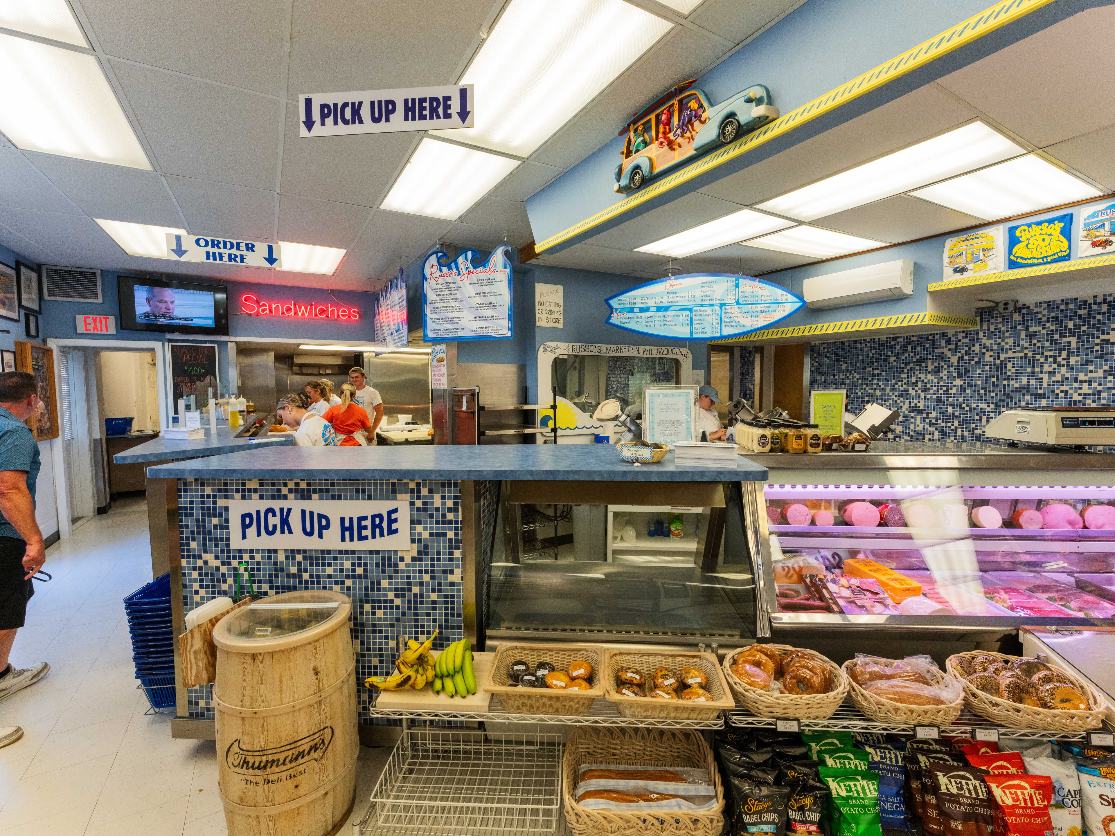 Colorful interior of deli counter with chips and meats on display.