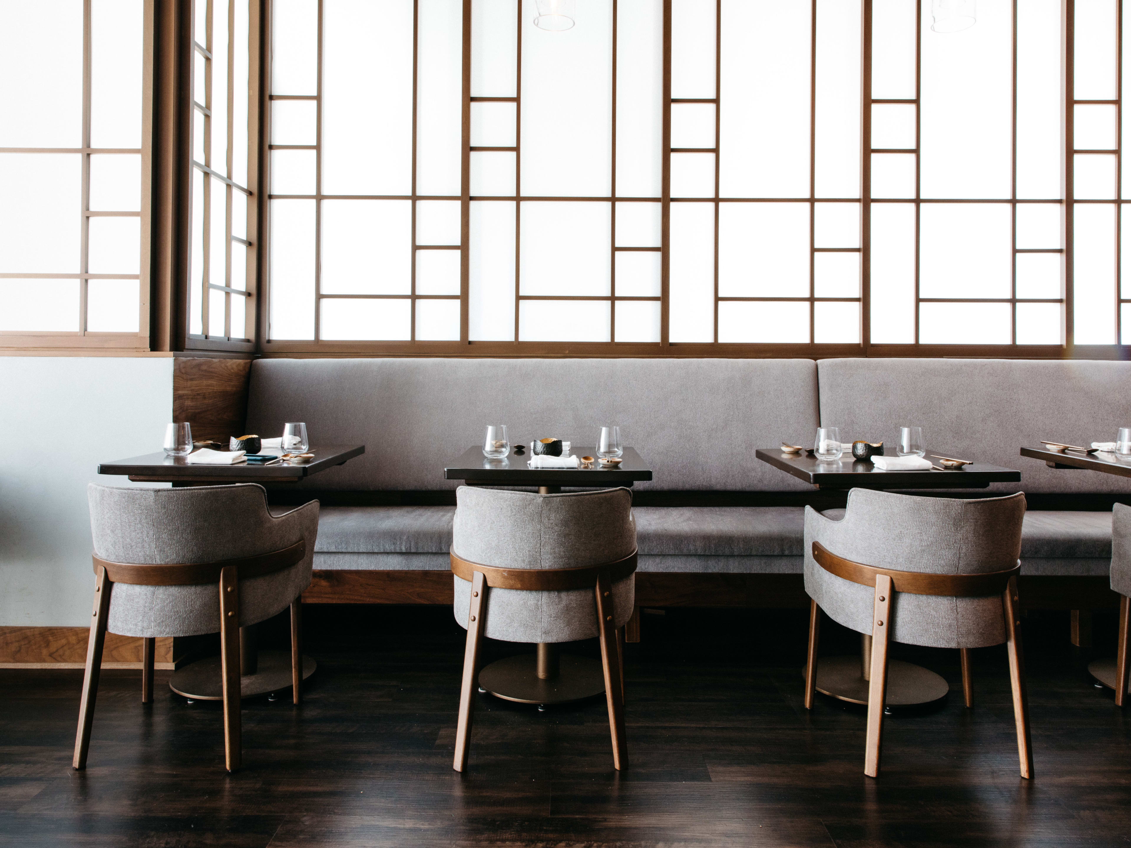 Small grey tables along a banquette at Jeong.