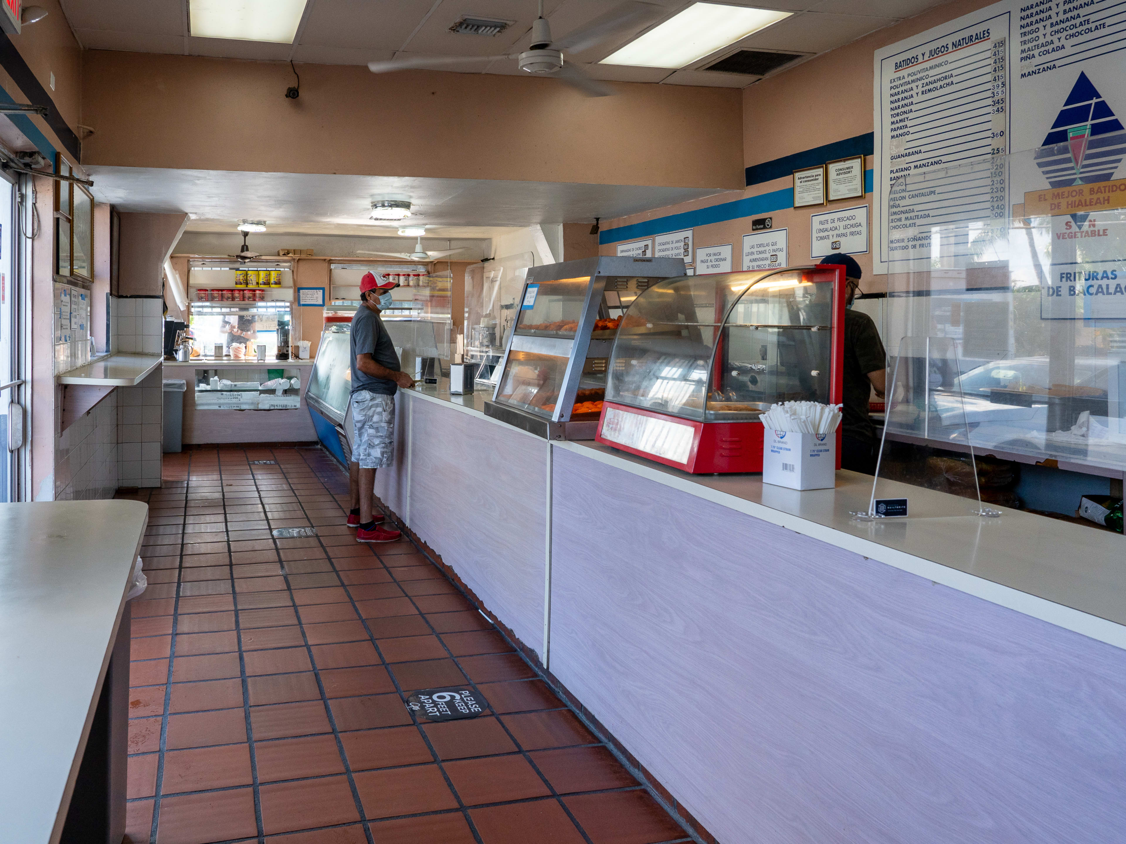 A casual Cuban counter where one man is placing an order.