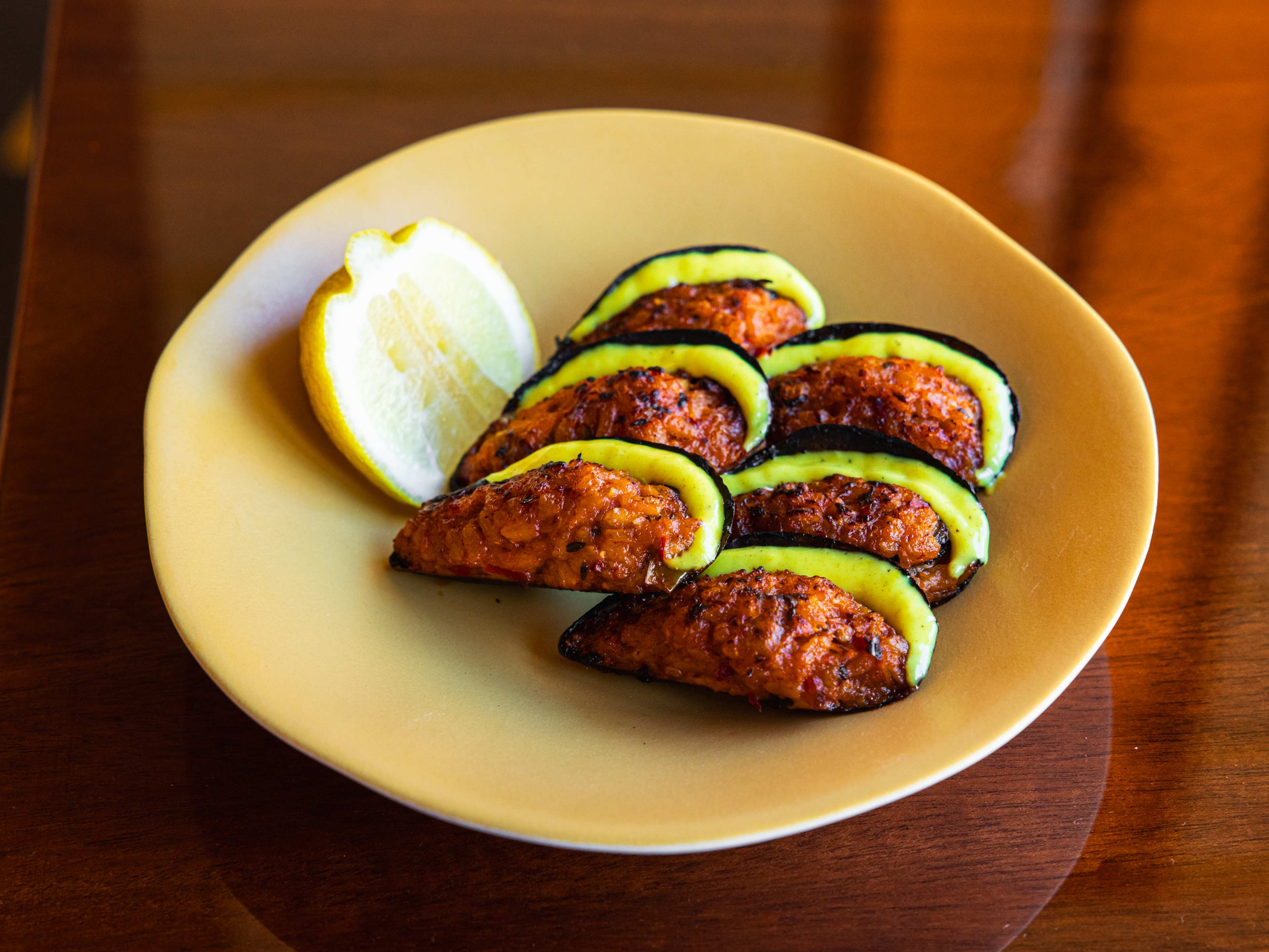 'nduja stuffed mussels with a lemon wedge