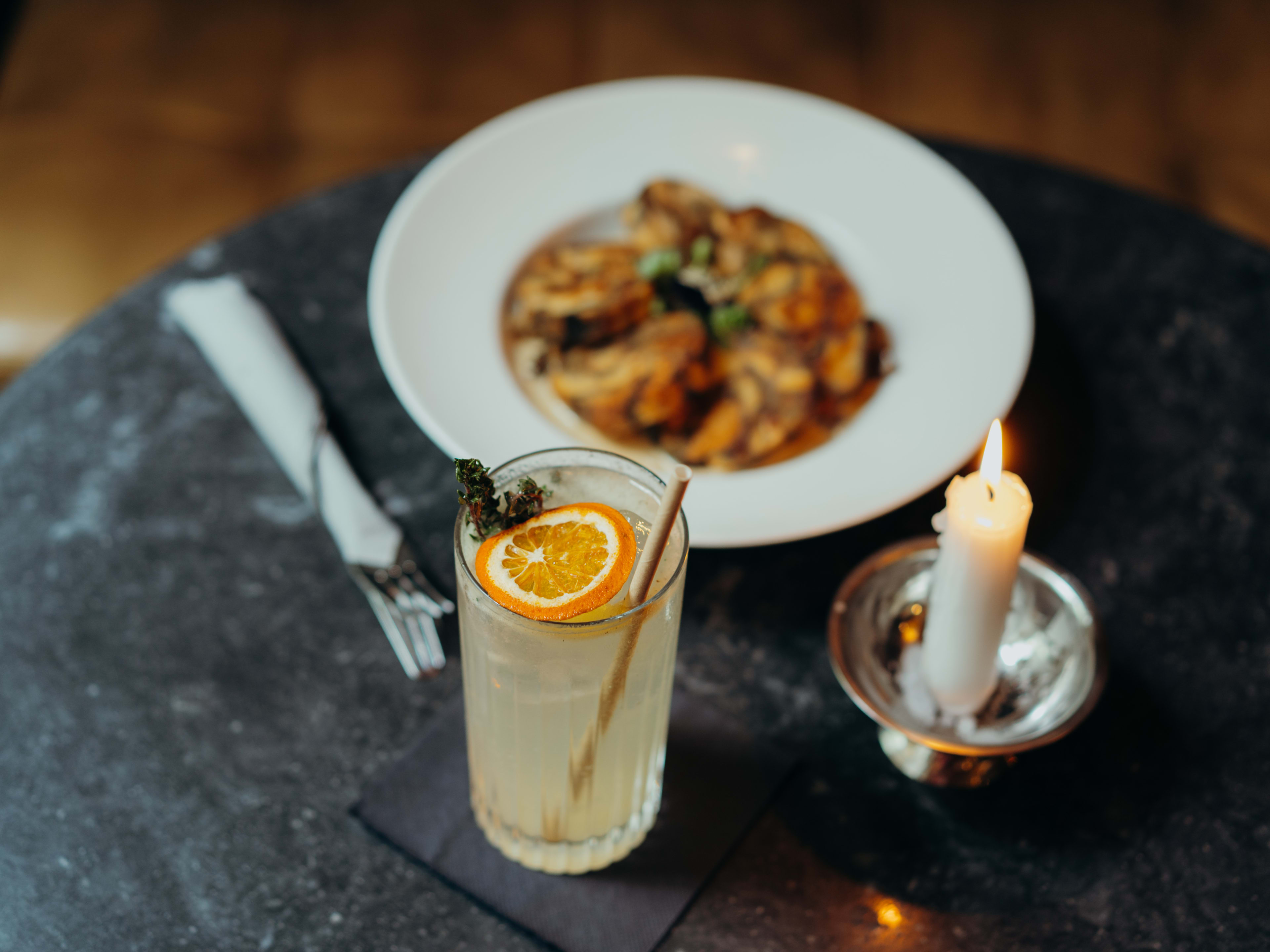 Cocktail and dish on black marble table at Schwarzes Cafe