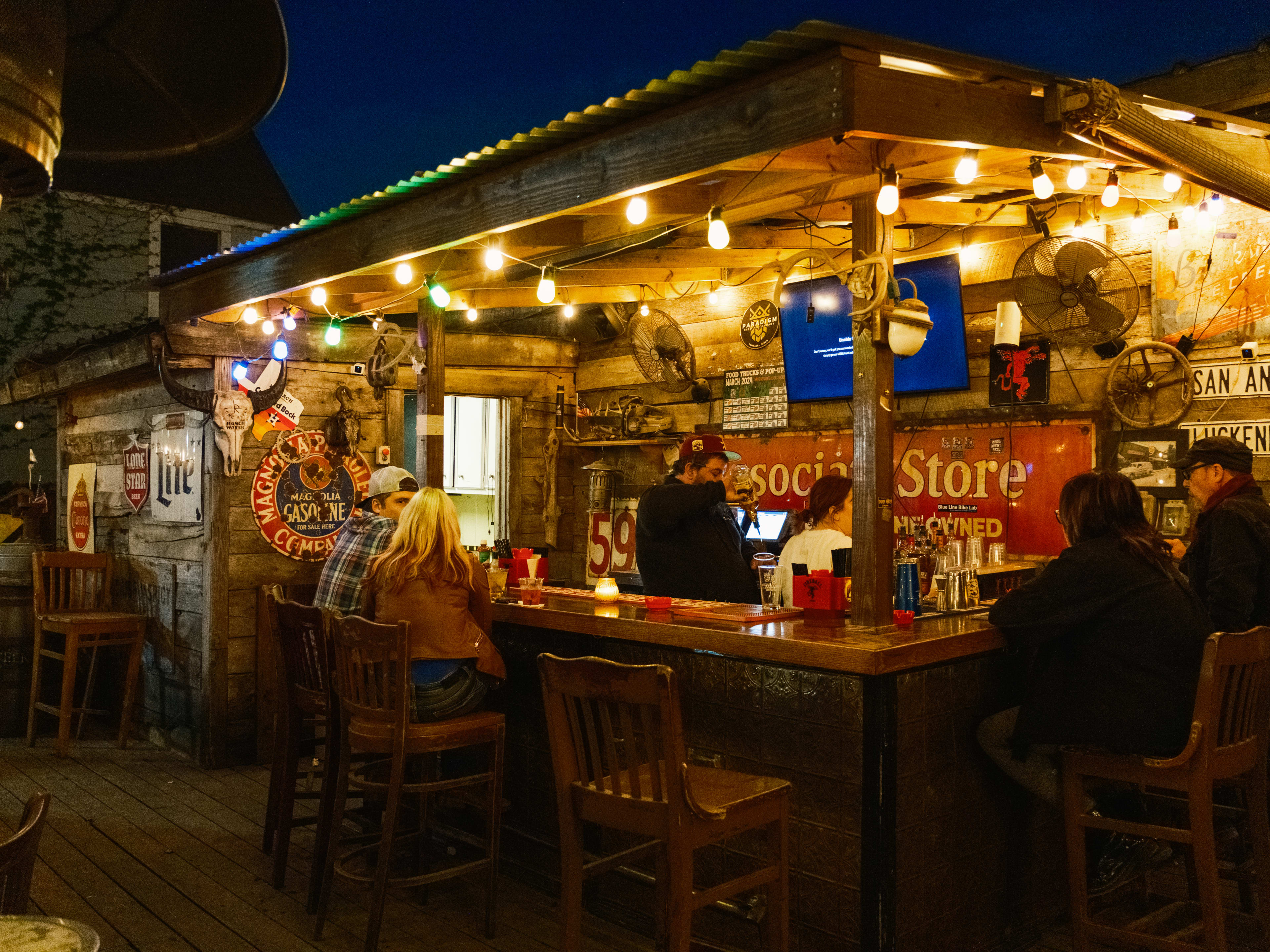 People sit at the exterior bar at Shady Acres Saloon.