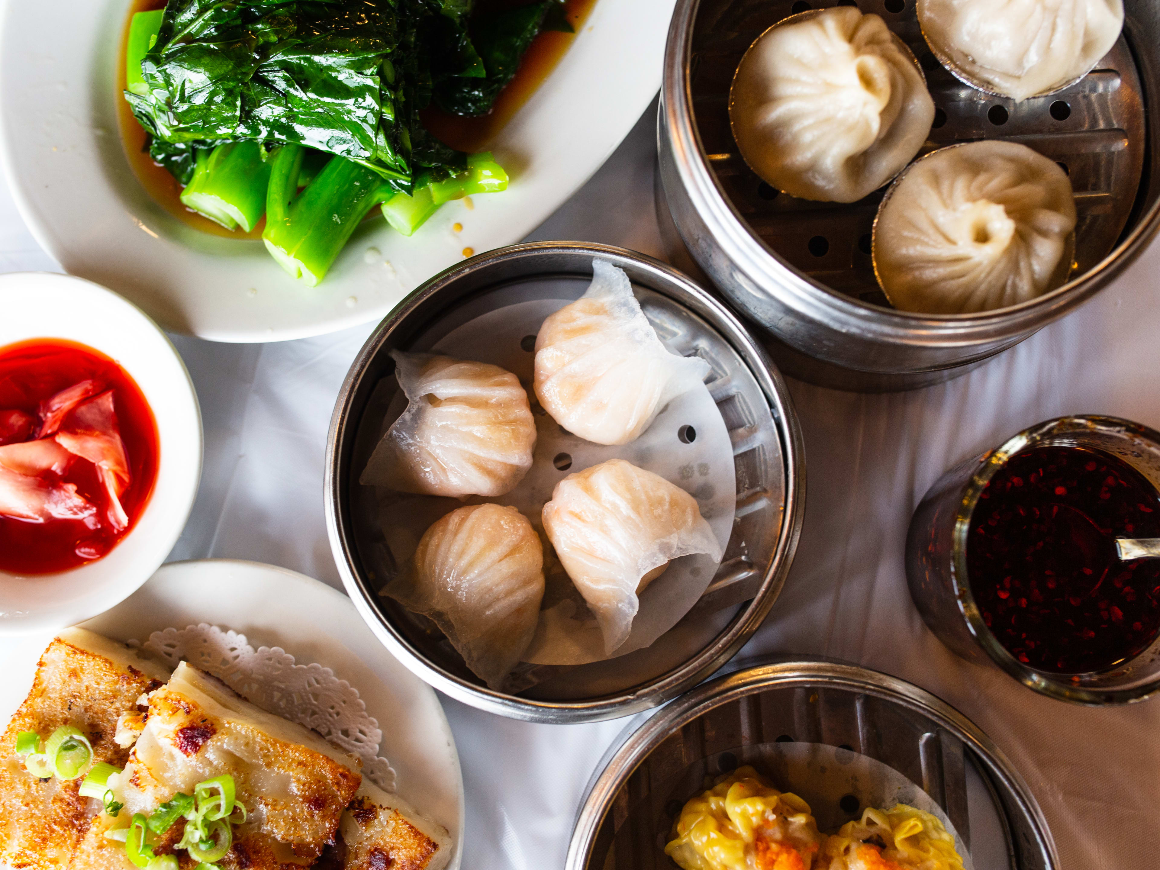 Various dishes from Shanghai Chinese Restaurant on a white plastic table cover.