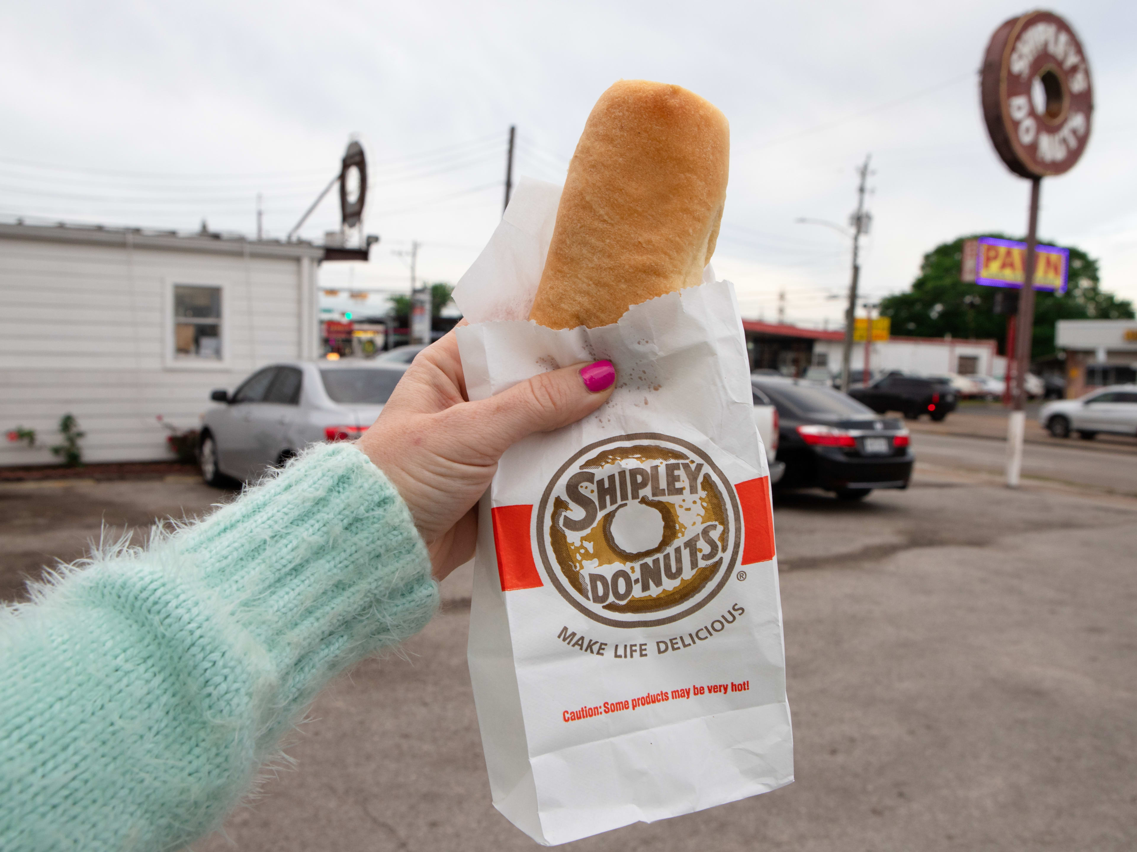 A jalapeno sausage cheese kolache held out of it's Shipley's Do-Nuts bag.