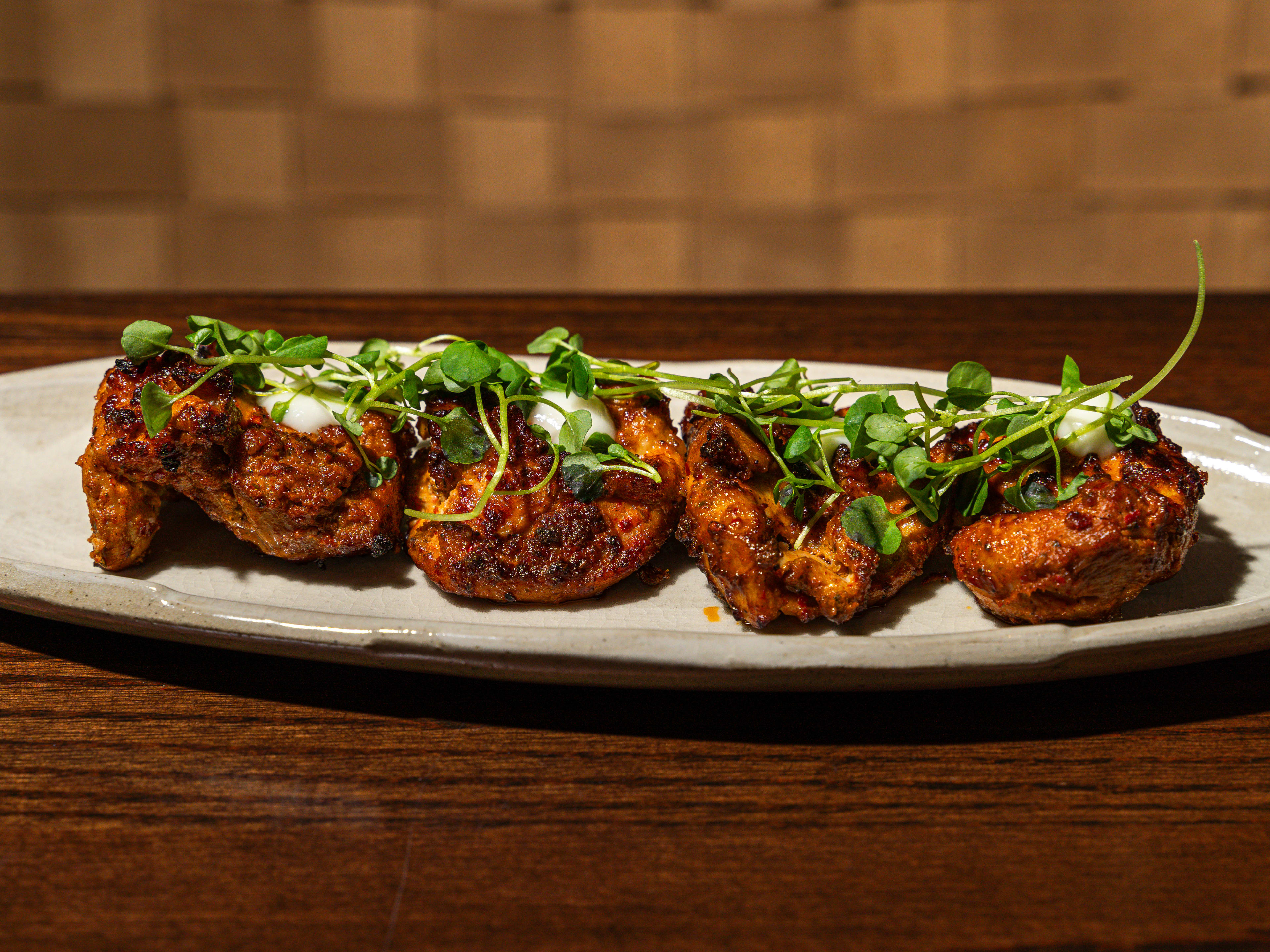 Plate of five pieces of grilled chicken shish taouk topped with microgreens