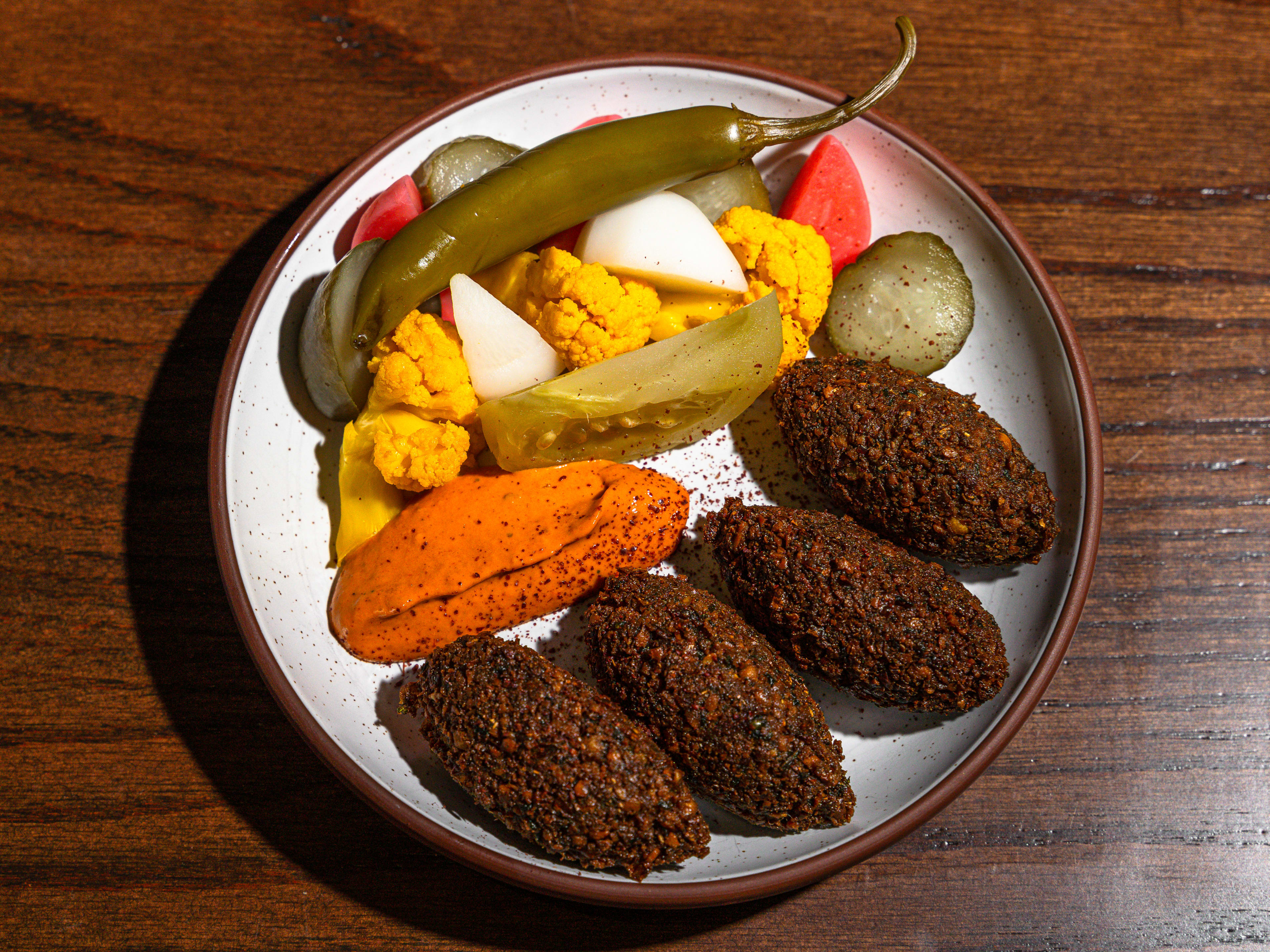 Plate of four falafel with pickled vegetables