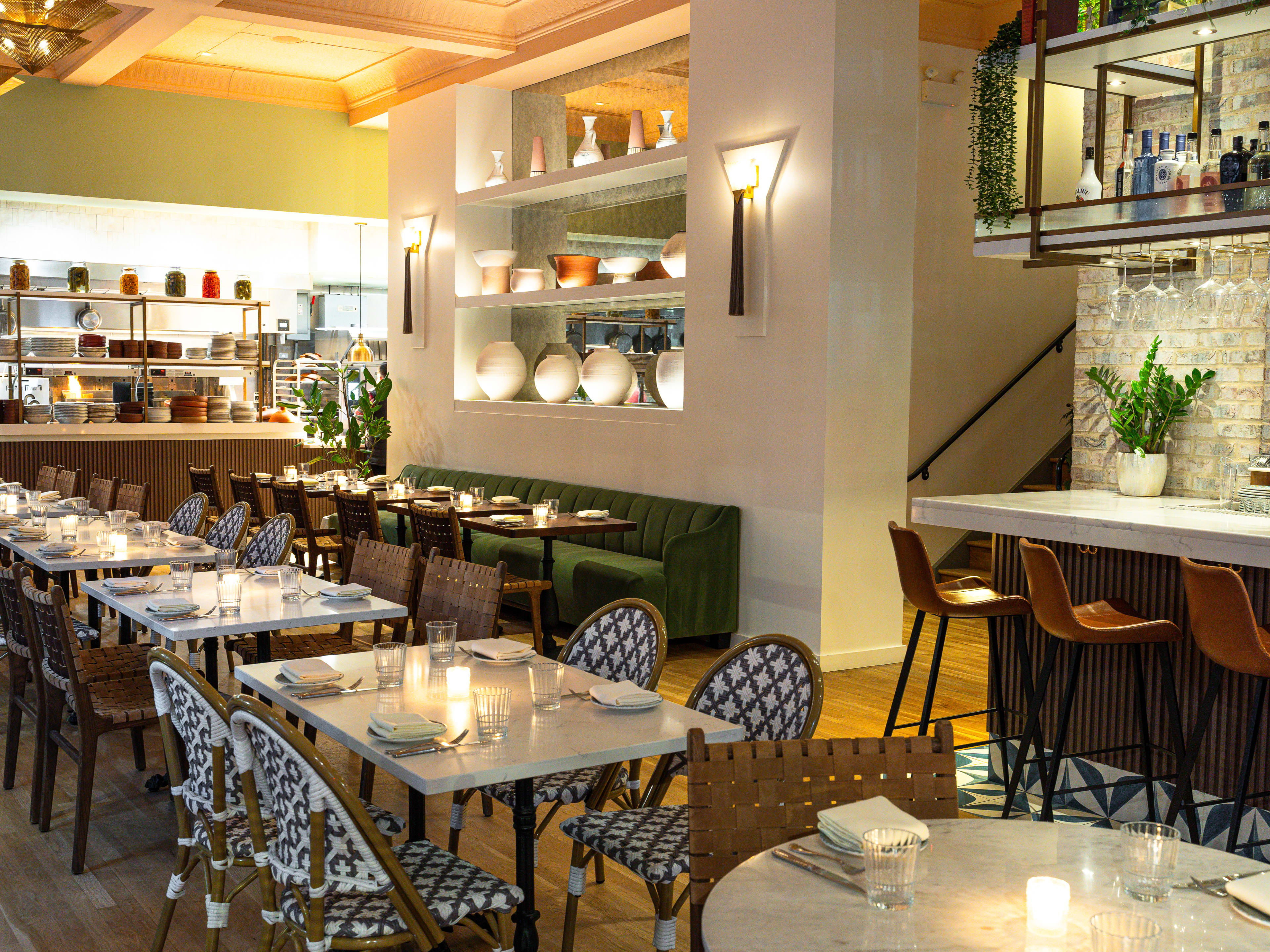 View of kitchen and banquette seating and stairs up to rooftop at Sifr