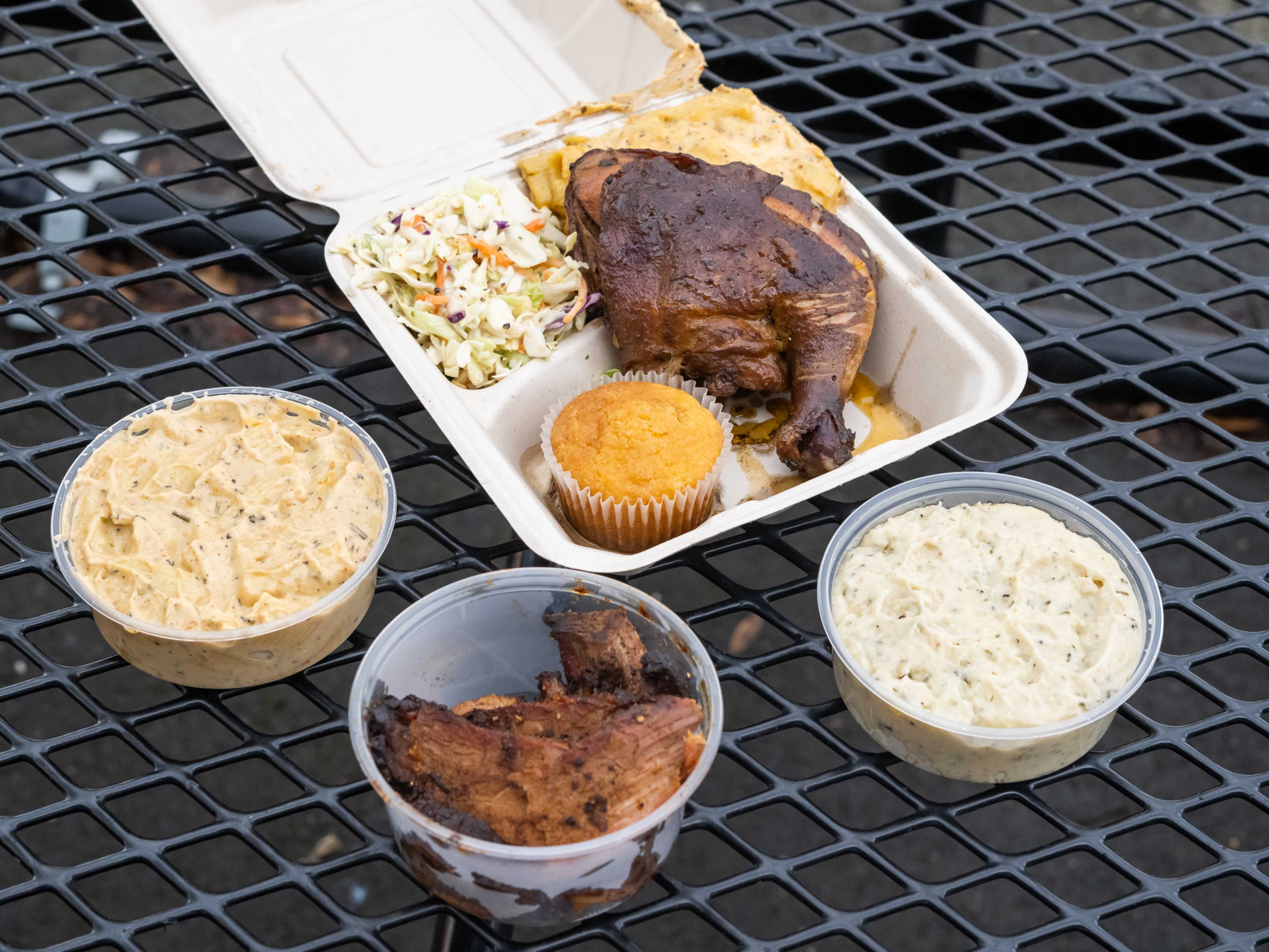 takeout spread of chicken, mac and cheese, cornbread muffin, and mashed potatoes