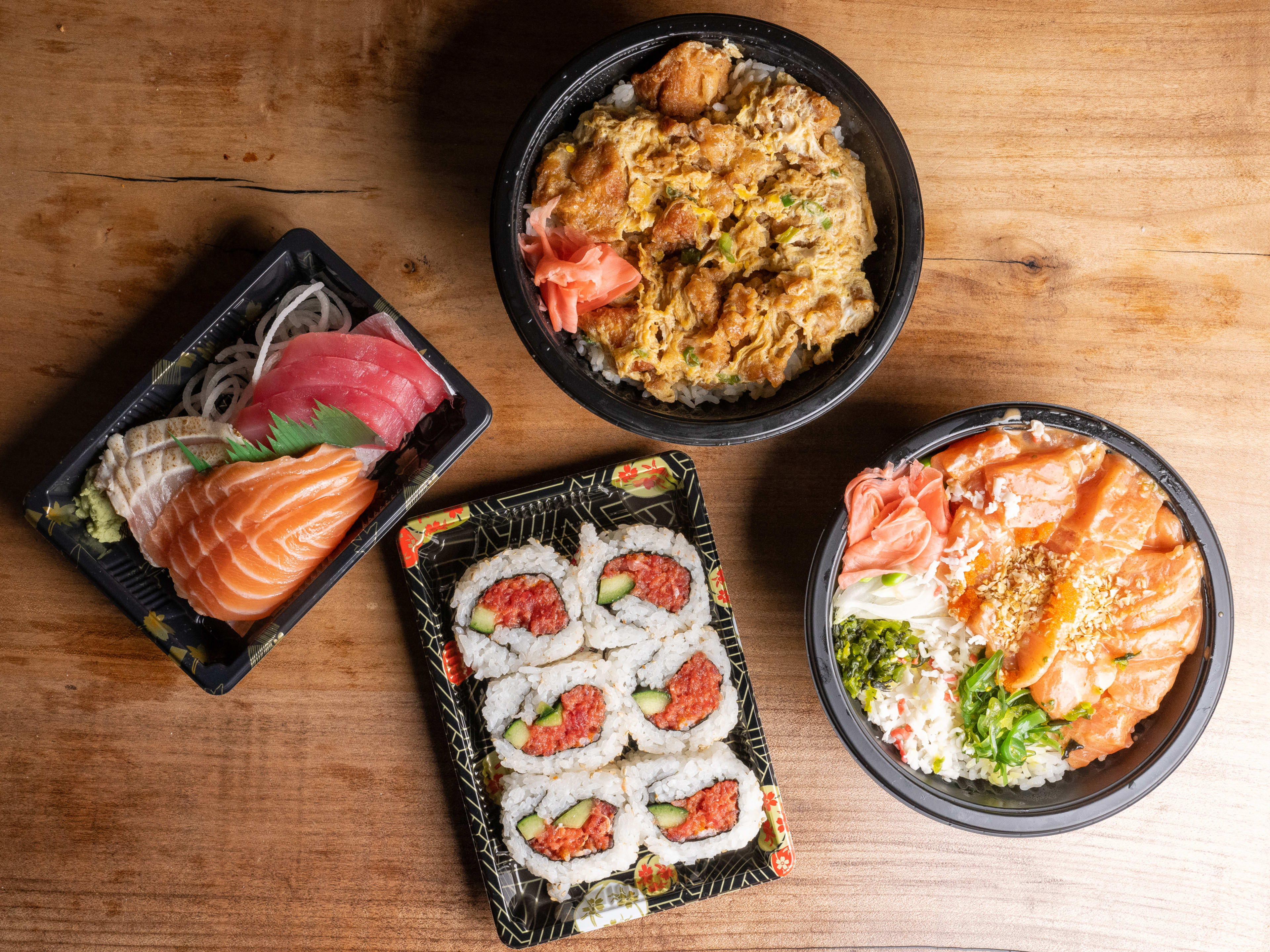 Spread of poke bowl, karaage bowl, sashimi, and spicy tuna roll