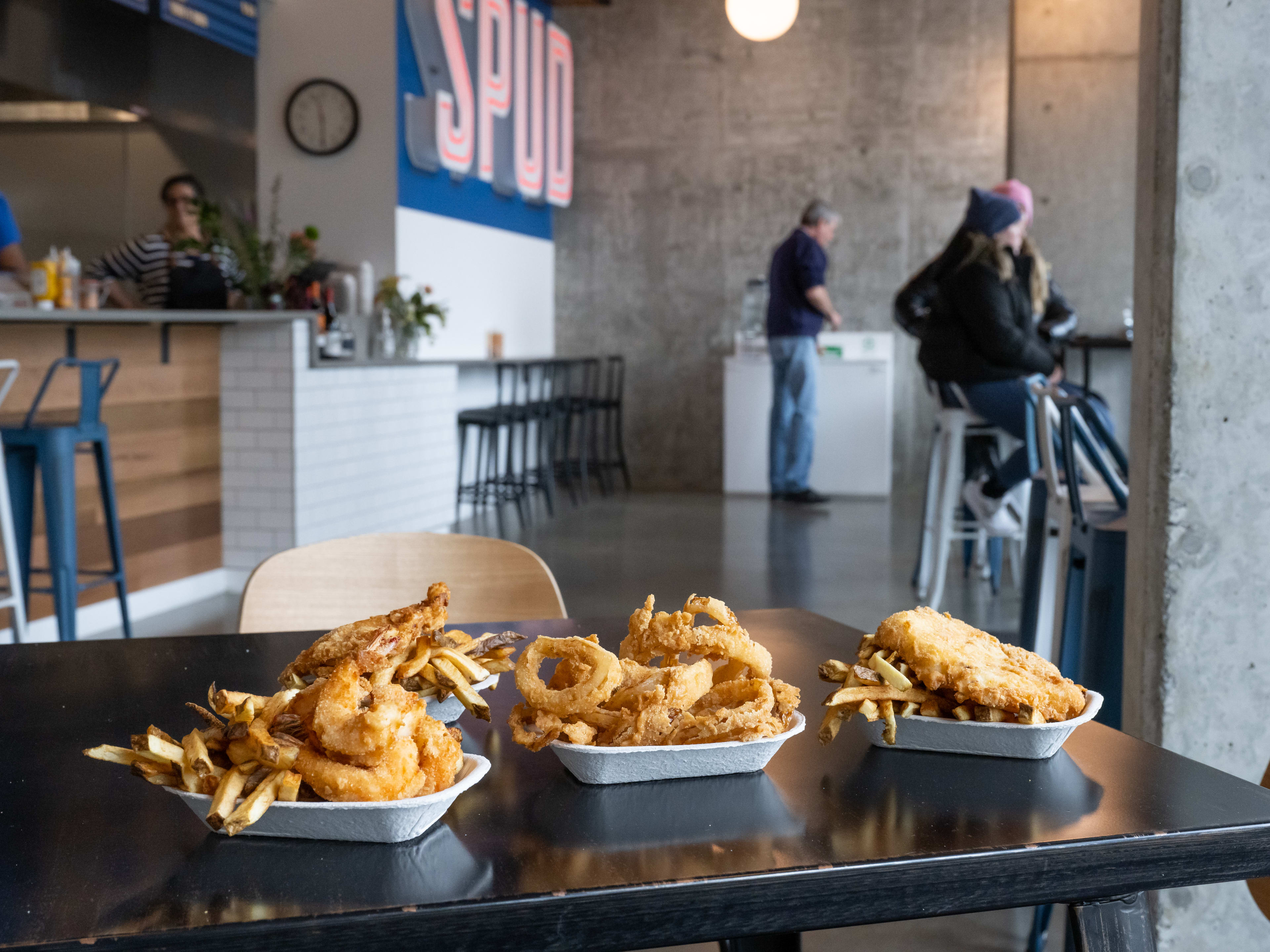 table with fish and chips, onion rings, and prawns and chips