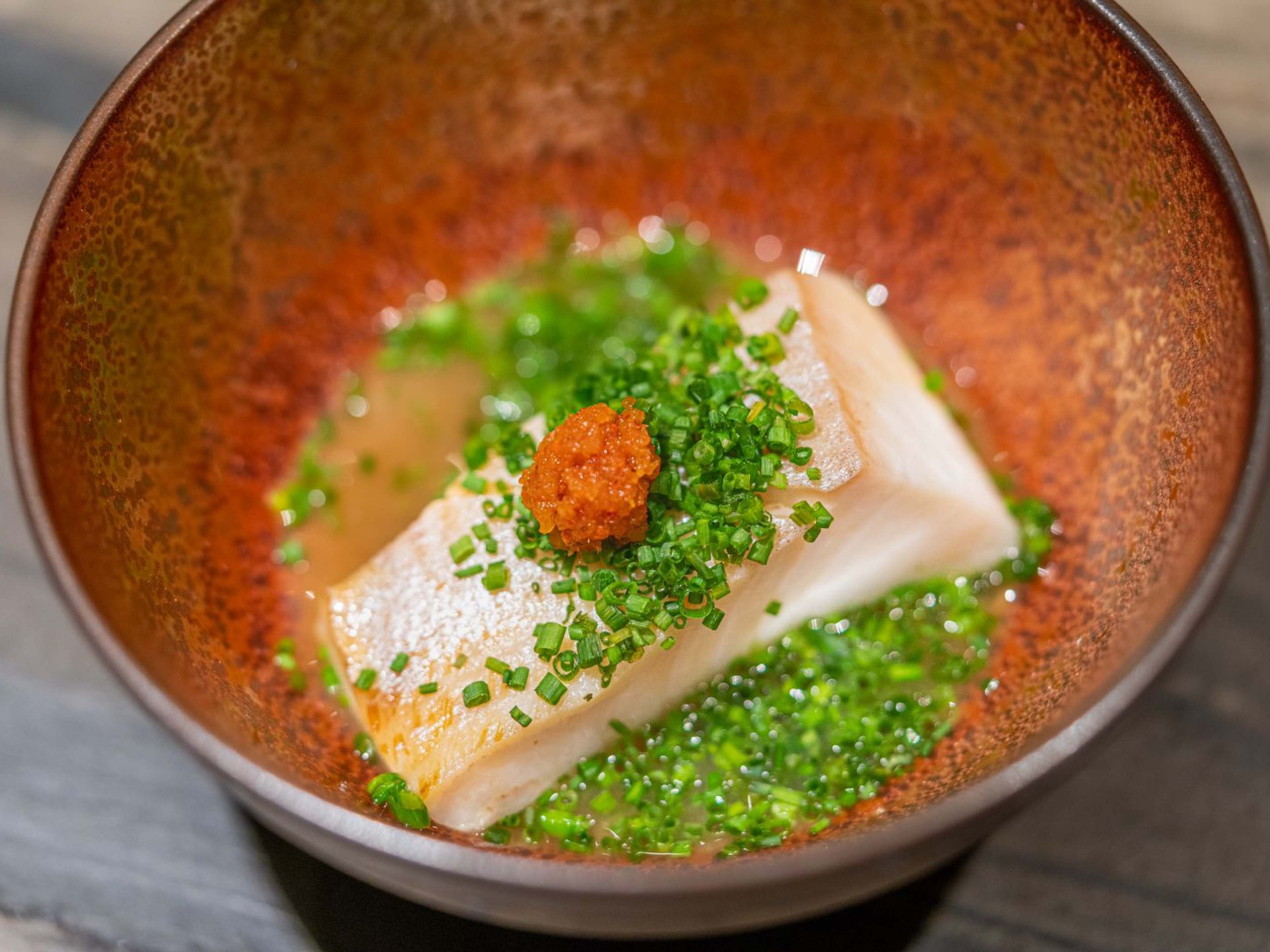 steamed fish in a broth with chives