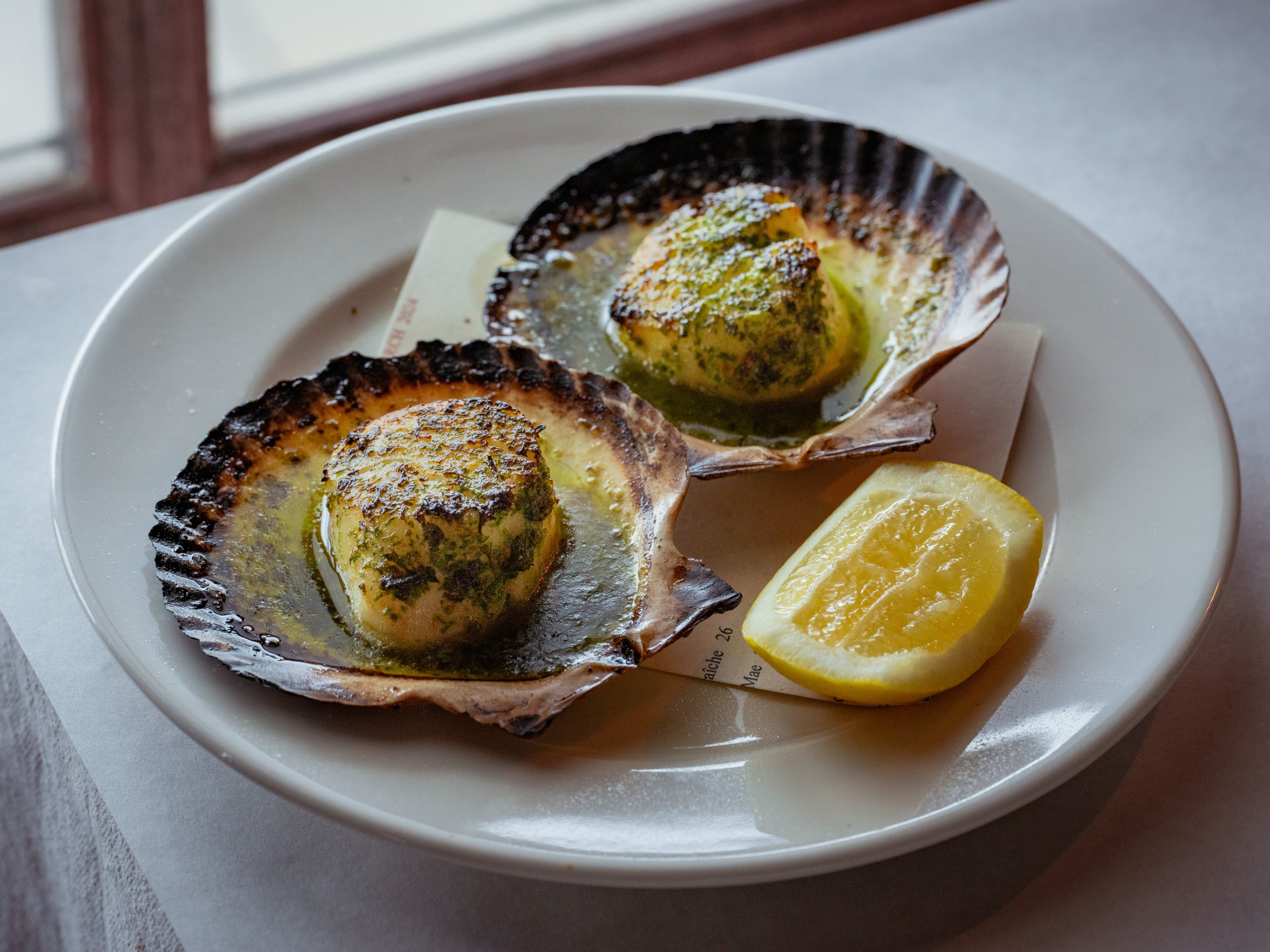 Scallops with green garlic butter served in scallop shells at Stissing House