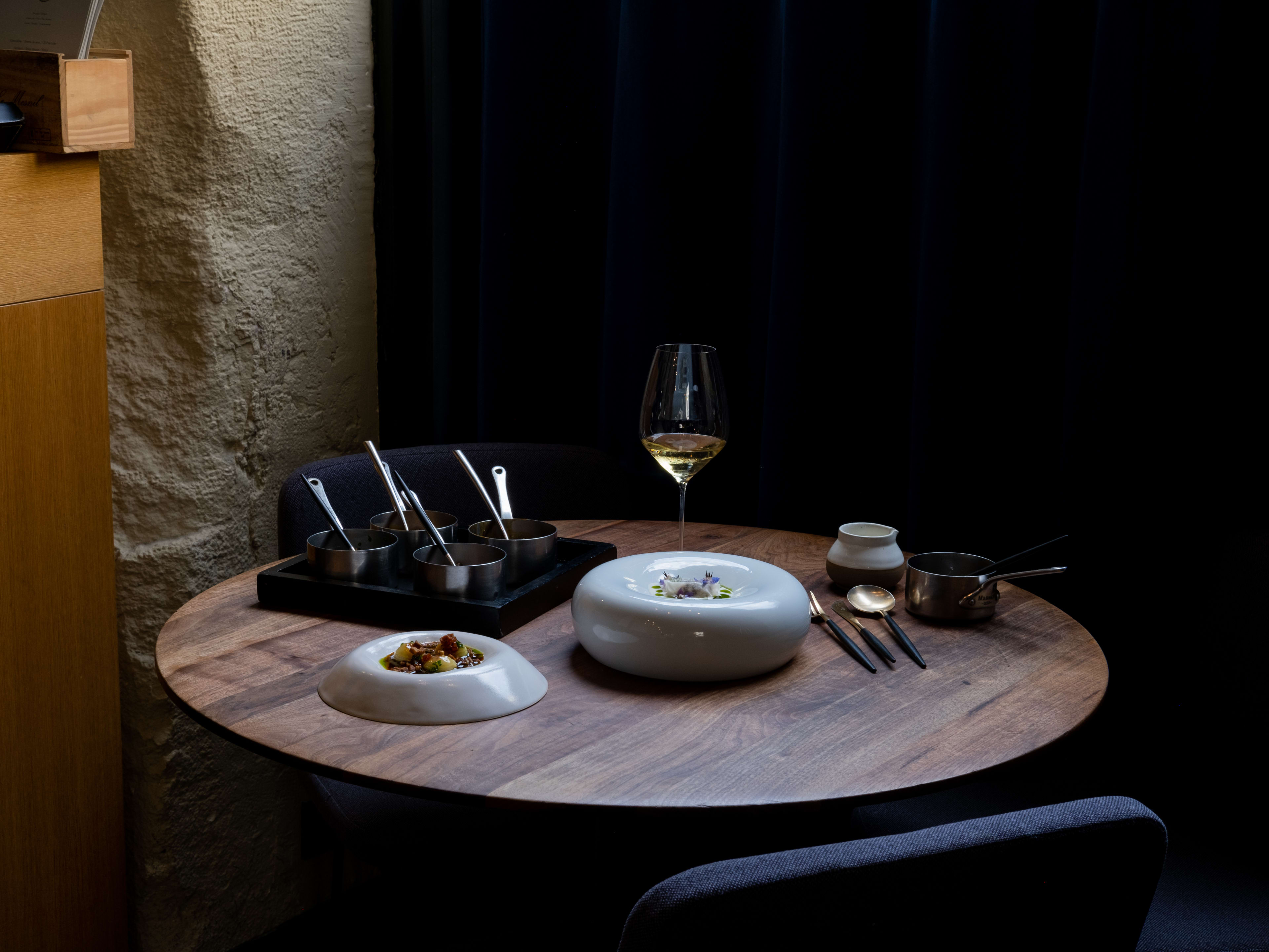 Plates and a glass of wine on the table at Substance, a fine dining restaurant in Paris