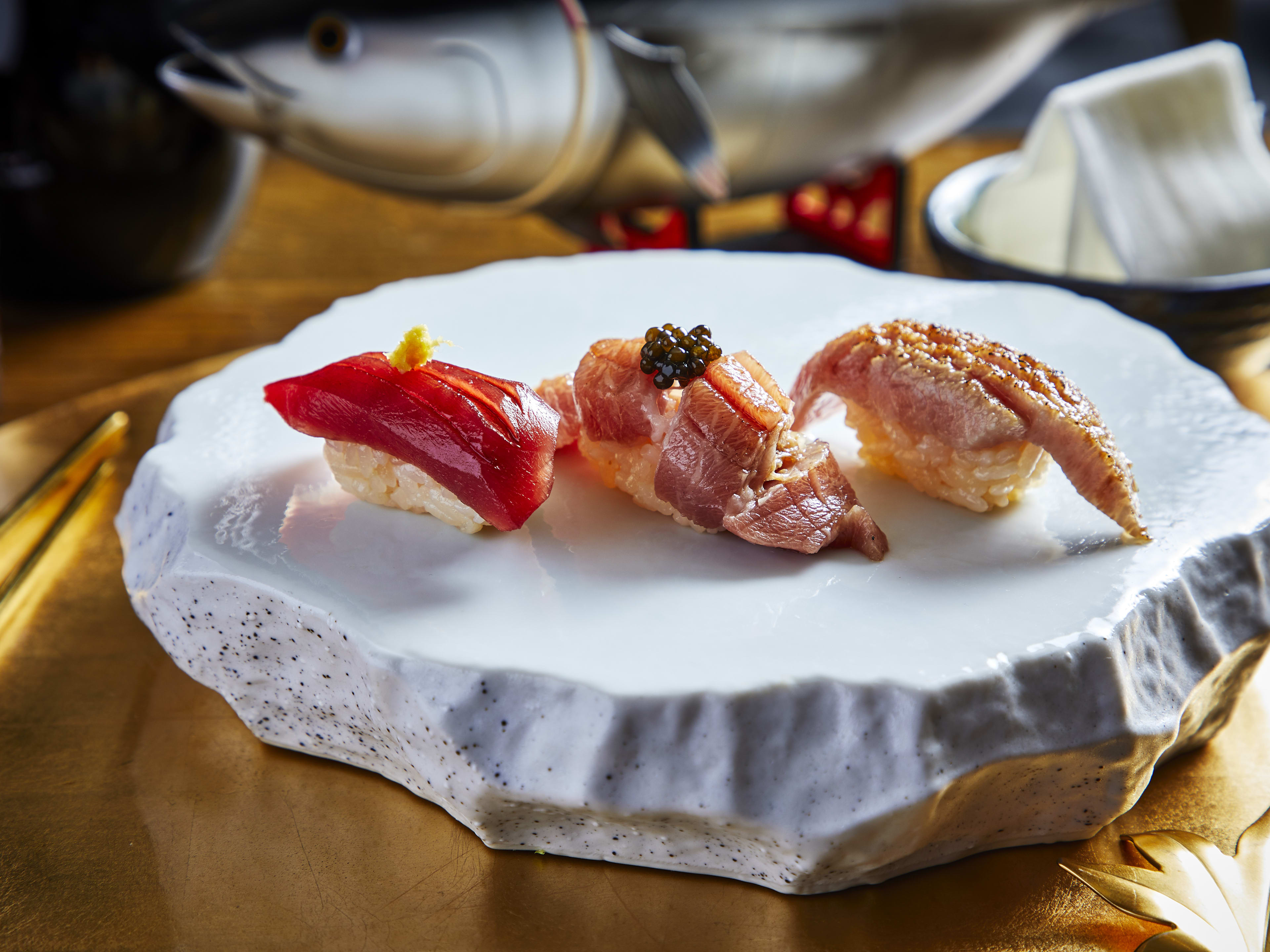 Trio of nigiri plated on a stone platter