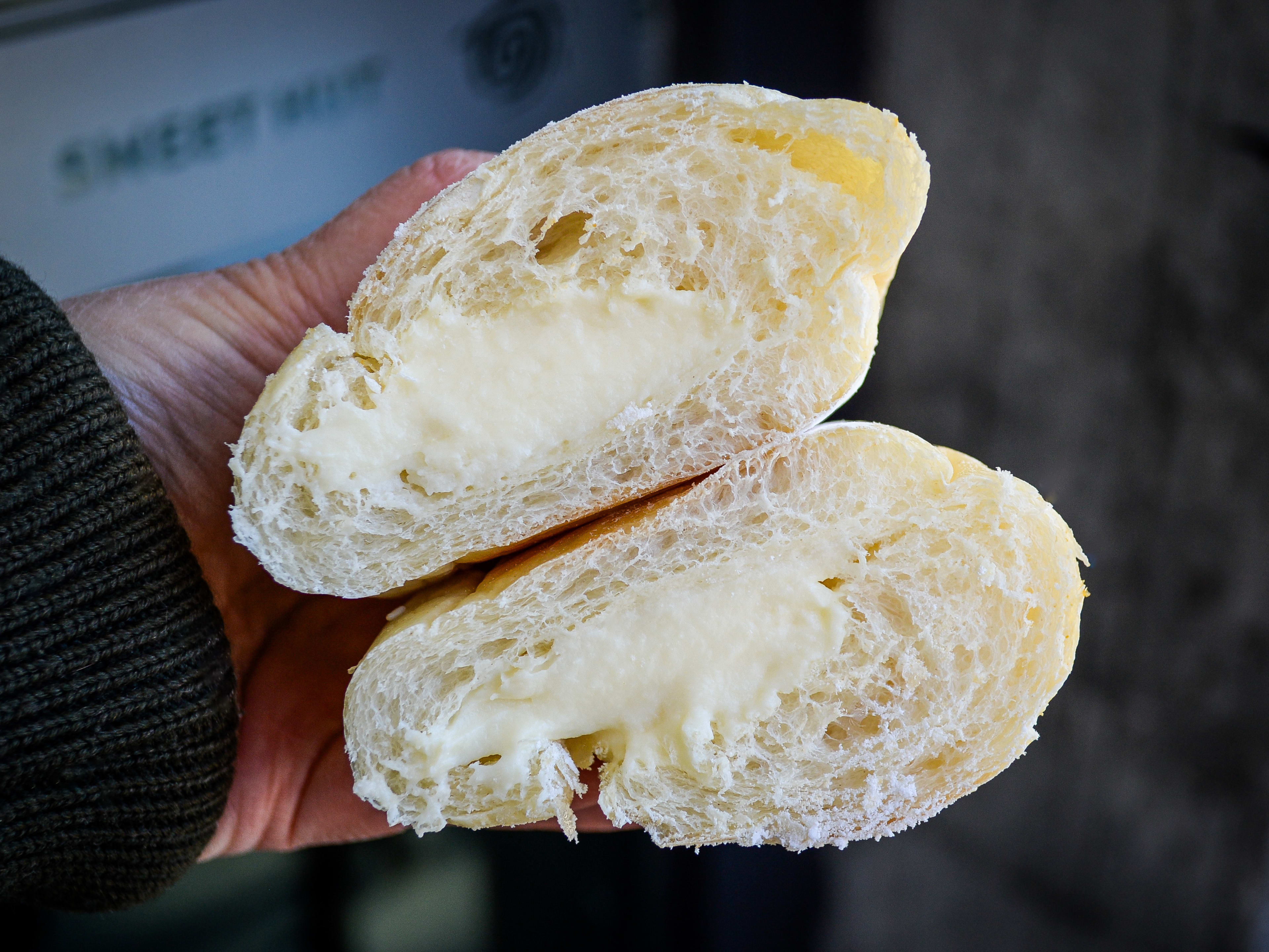 Bread bun filled with pastry cream, cut in half to show filling