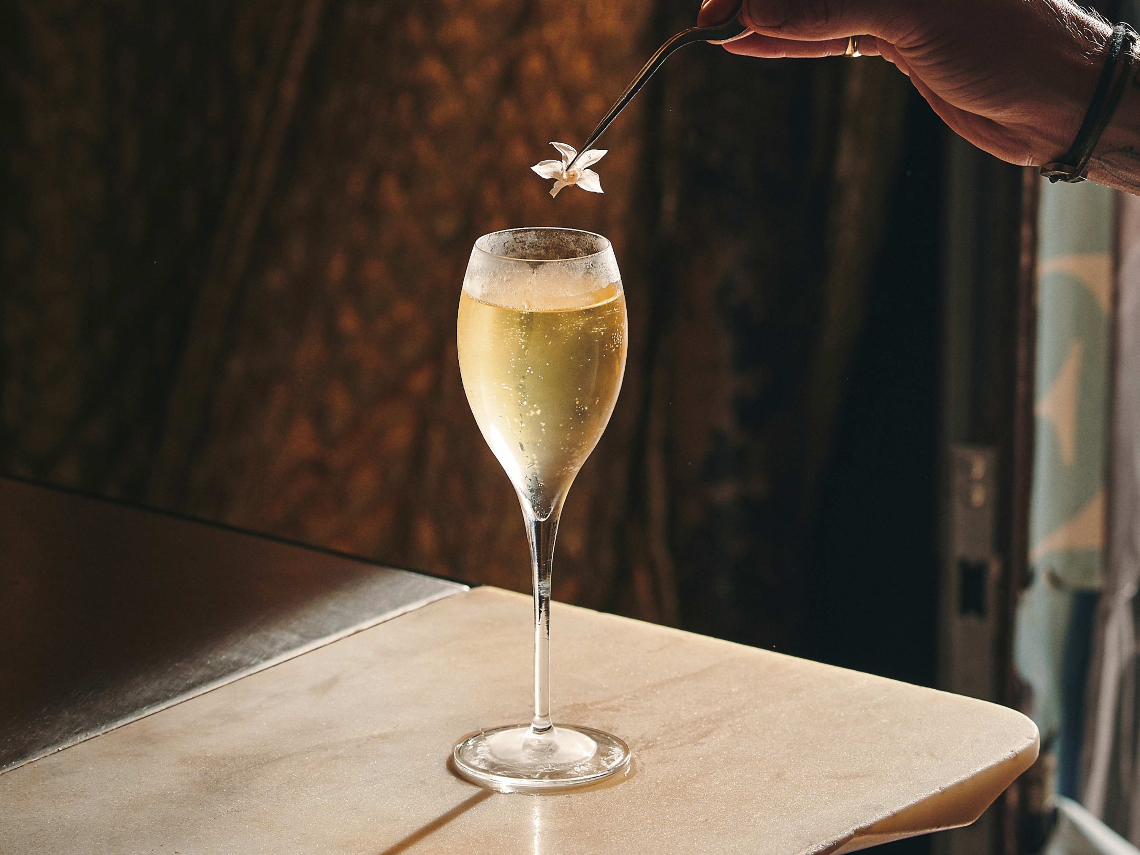 Champagne cocktail topped with edible flower at Le Syndicat