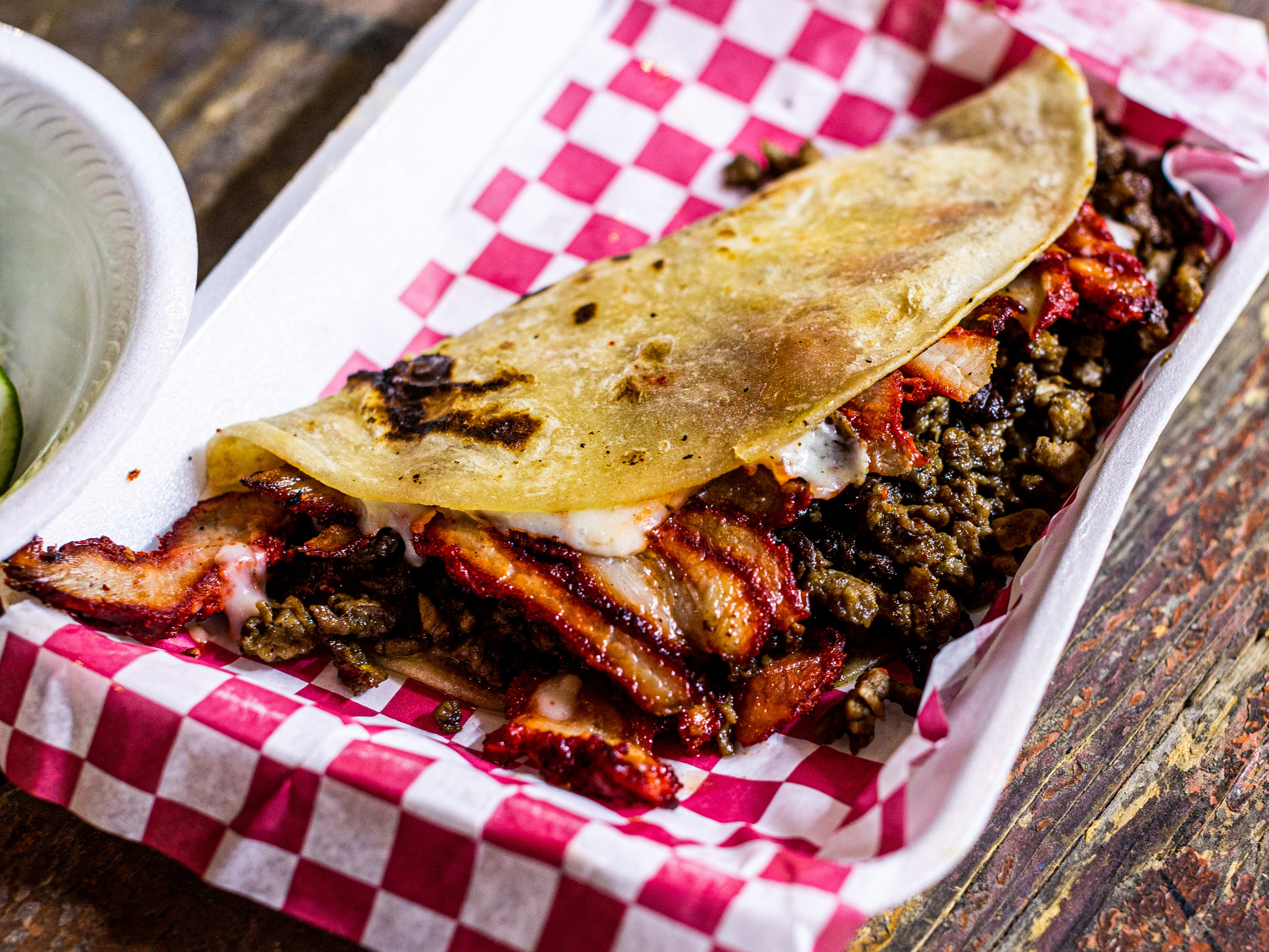 The Campechena Quesadilla from Tacos La Sultana served in a styrofoam dish with checkered paper.