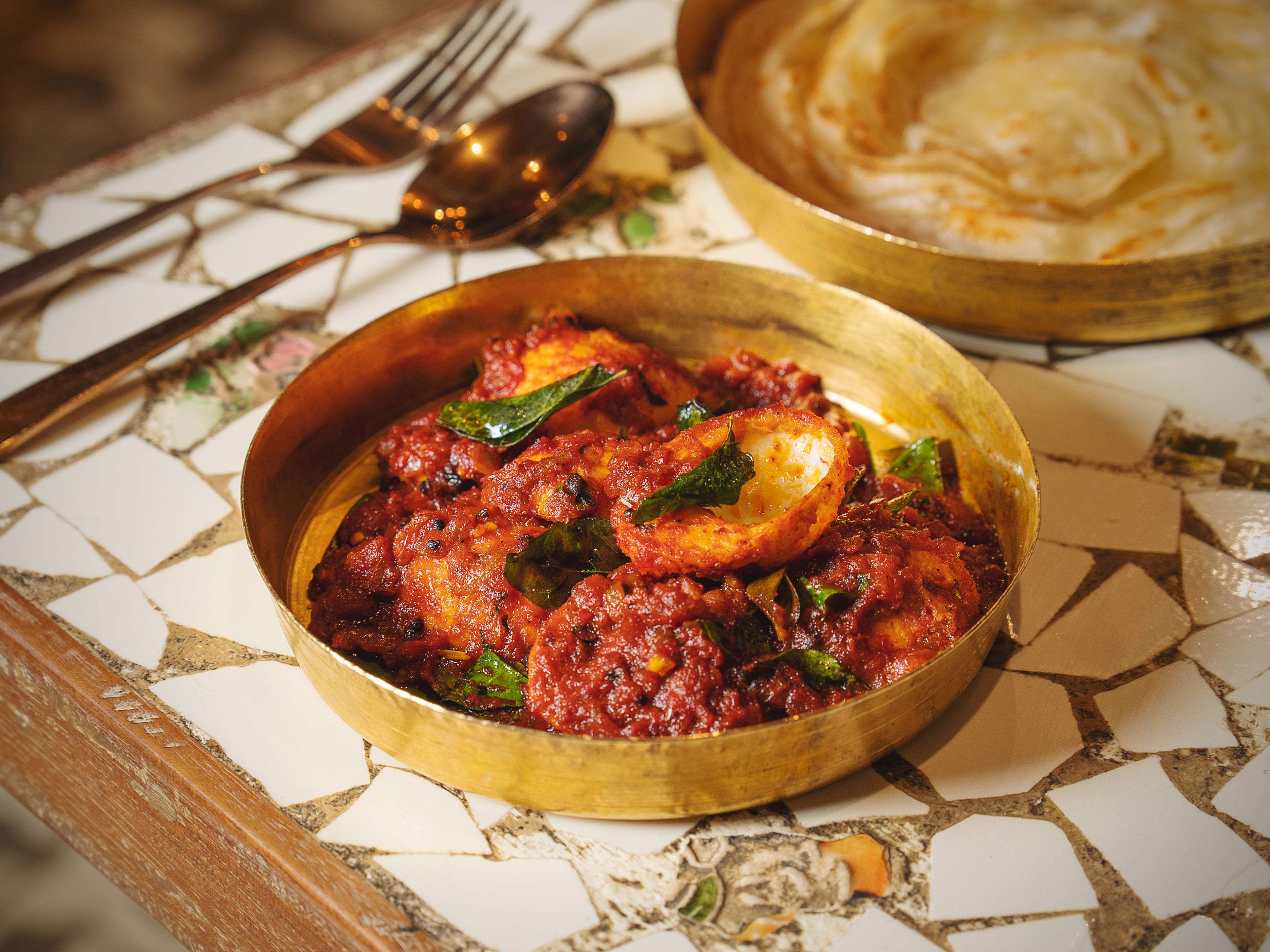 Egg thokku in small gold dish at the Tanjore Tiffin Room