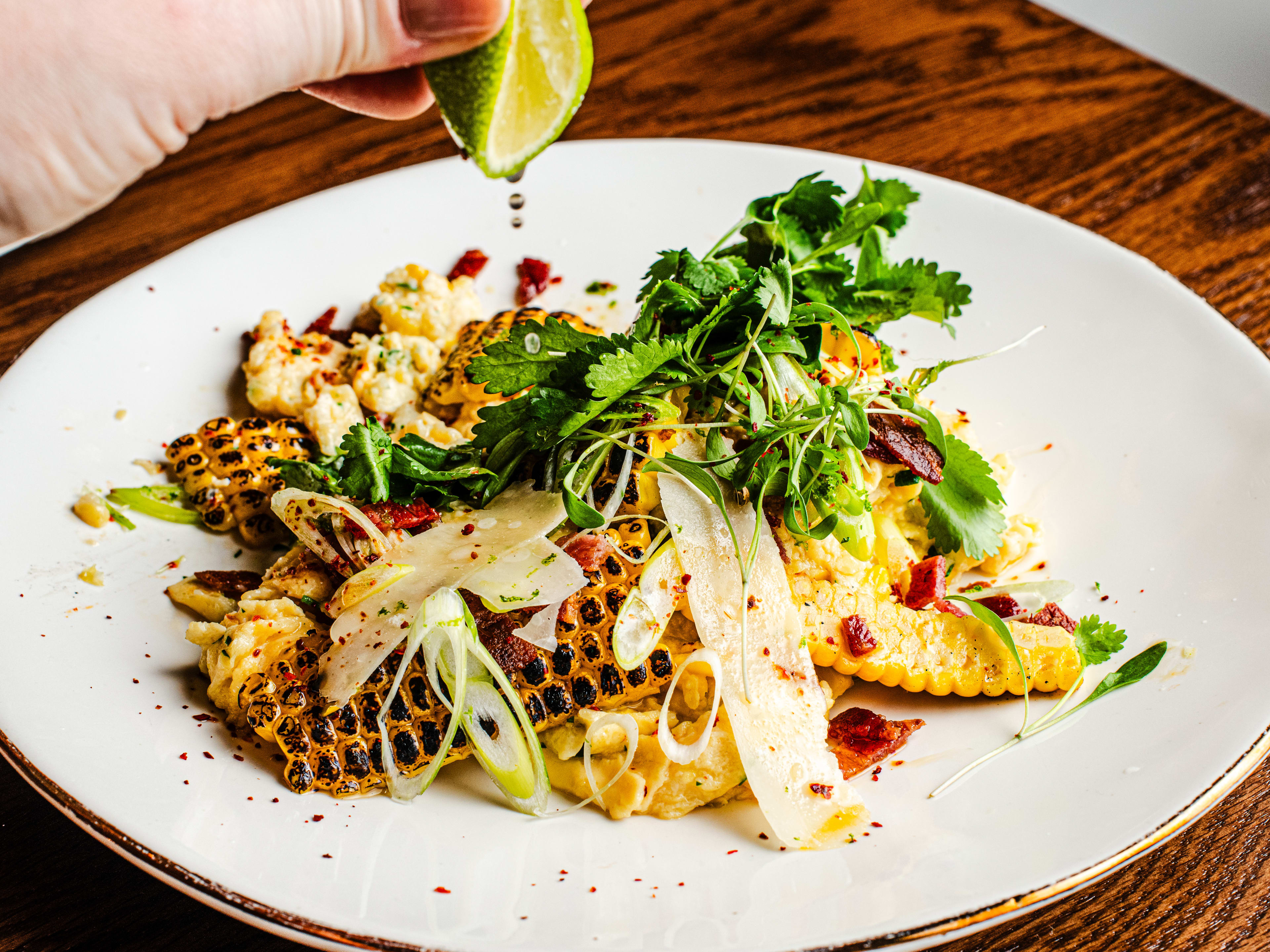 A lime is squeezed over a sweetcorn scramble.