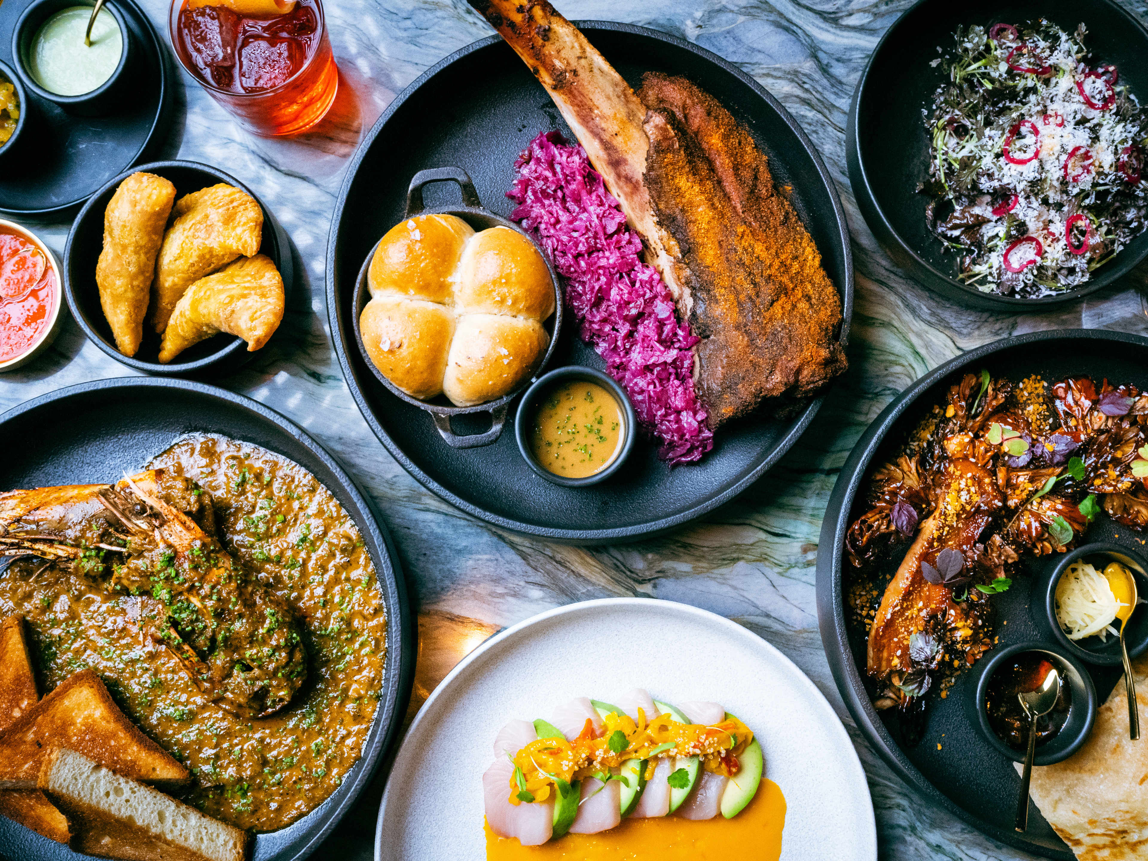 A spread of dishes on a marble table at Tatiana.