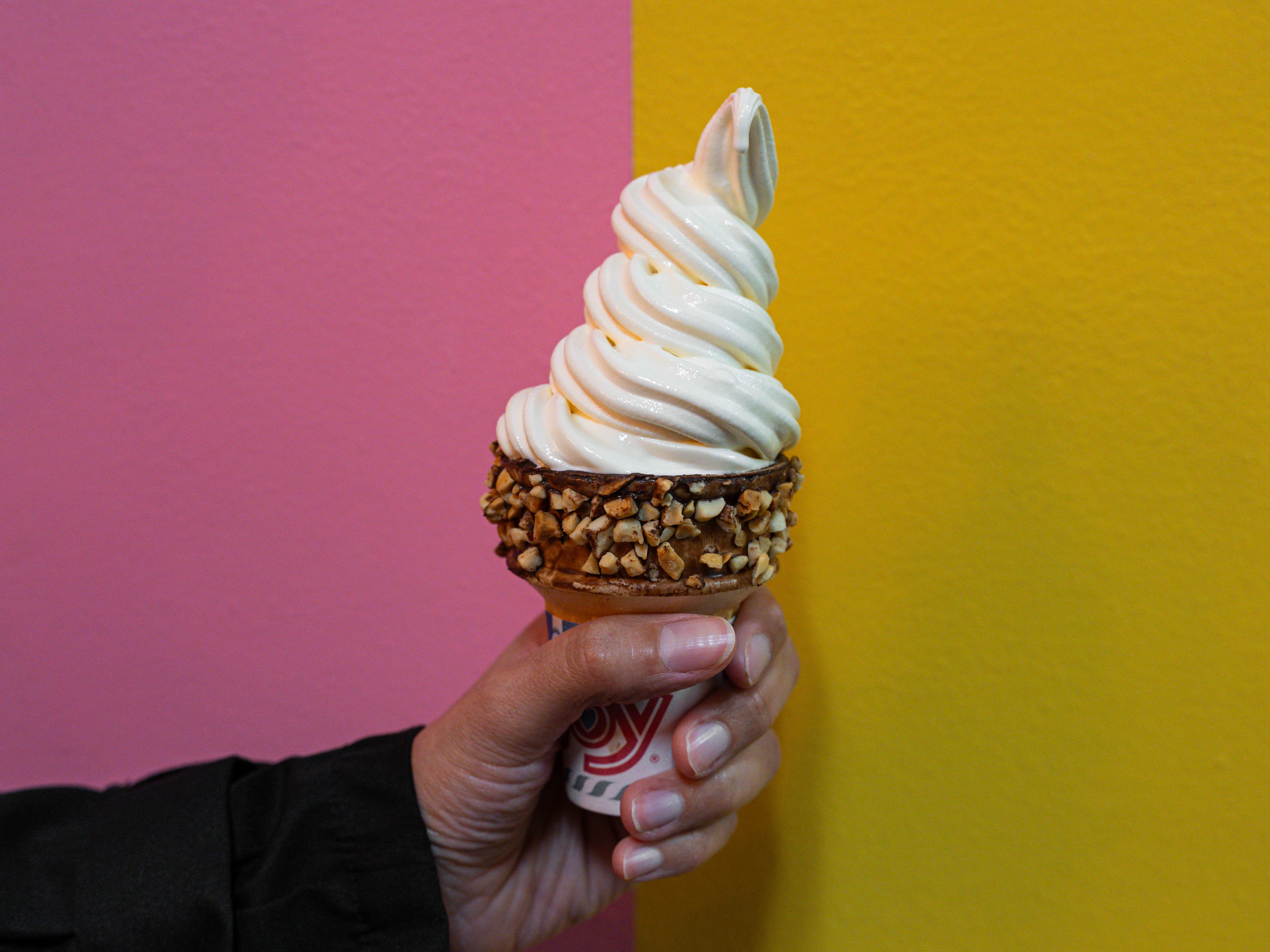 Vanilla soft serve in a chocolate dipped cone with nuts