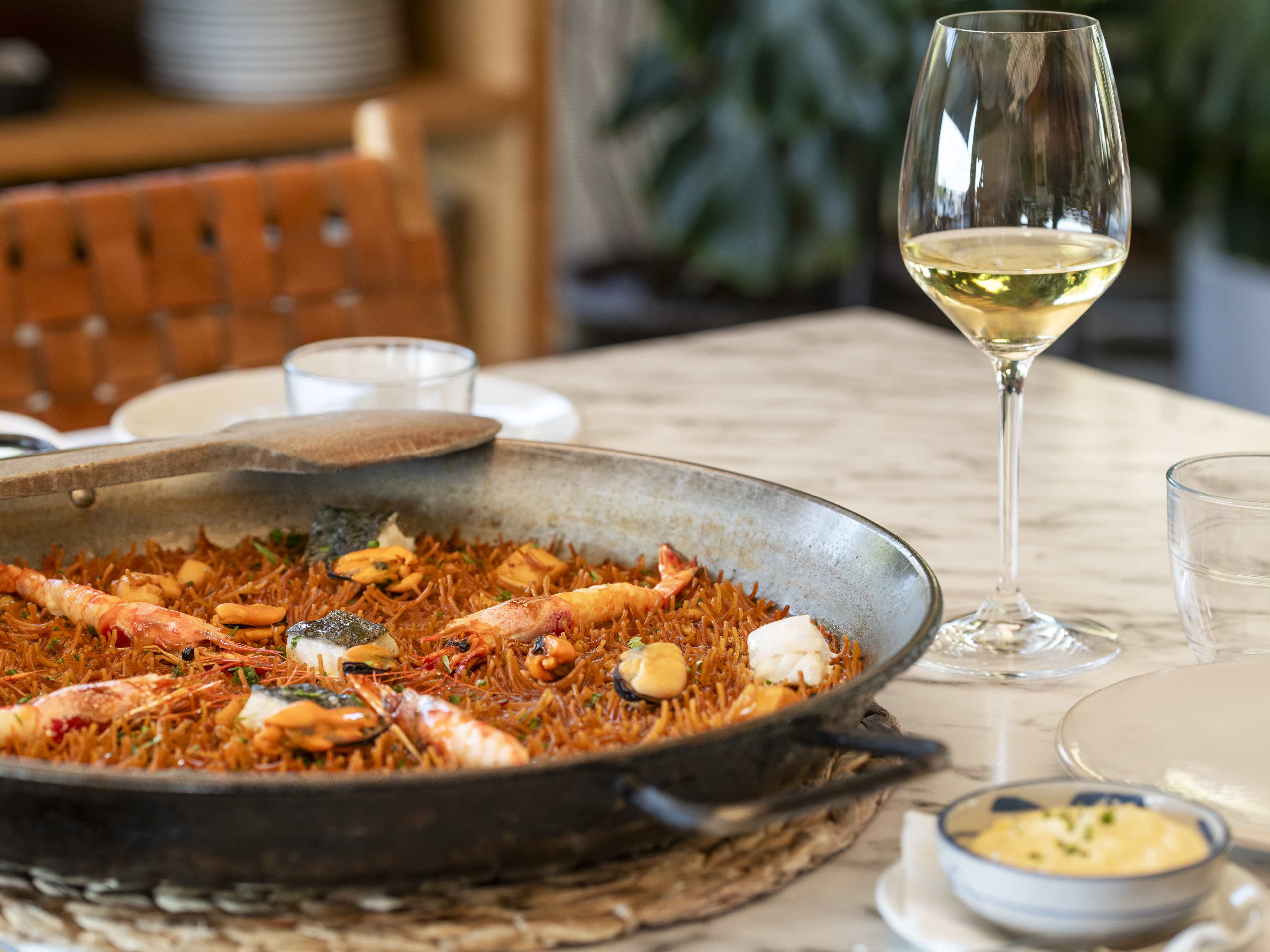 Seafood paella and glass of white wine at Terrazzo Martinez