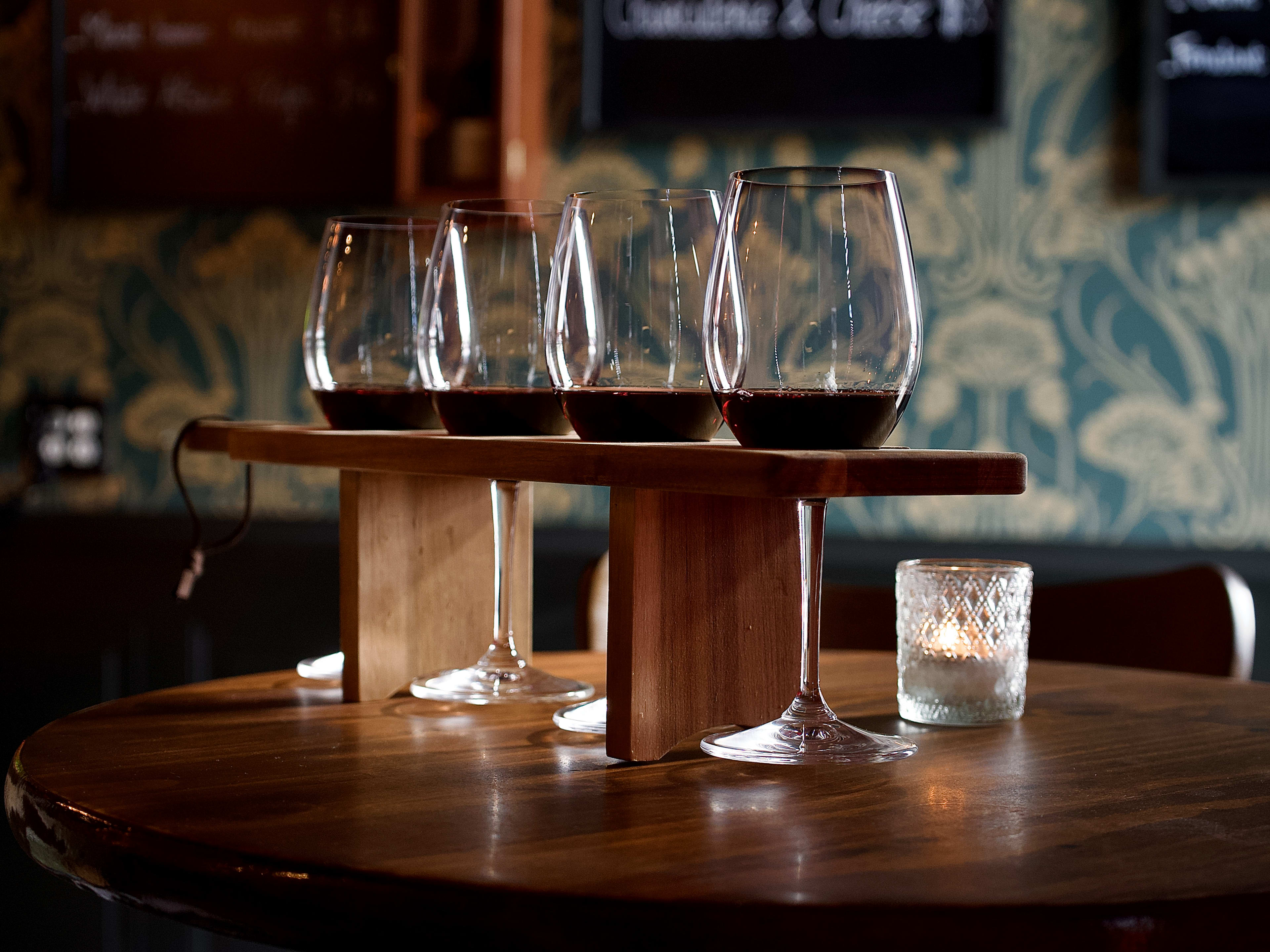 Flight of red wines in wooden carrier at The Authentique