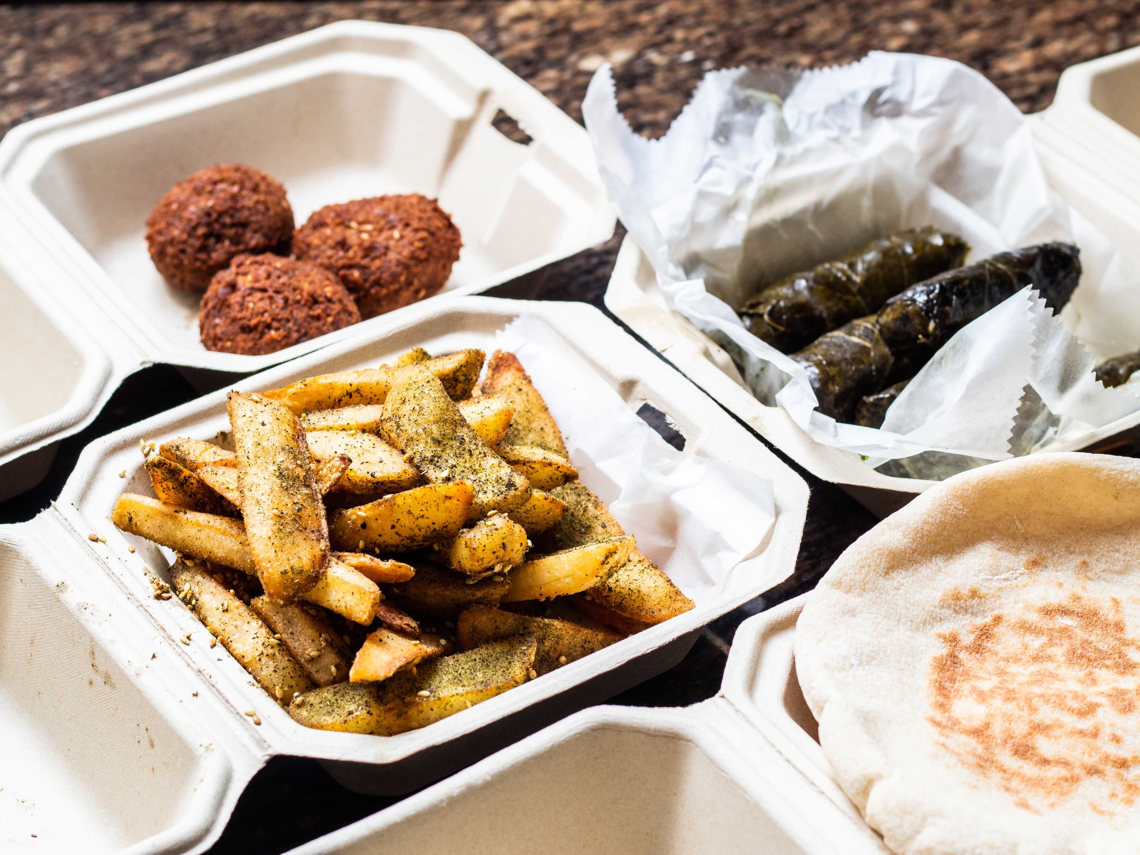spread of falafel, pita, grape leaves, and zaatar fries