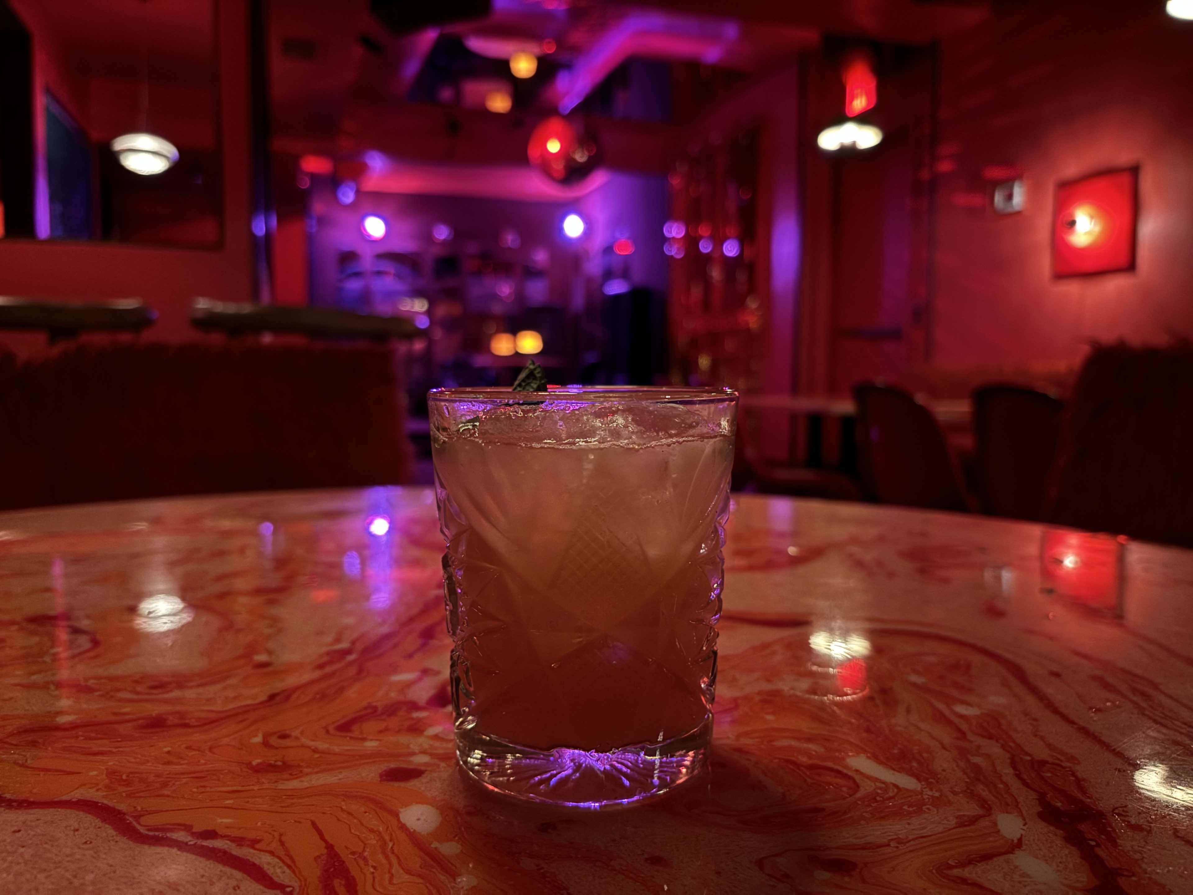 A hurricane sits on a table with a disco ball in the background.