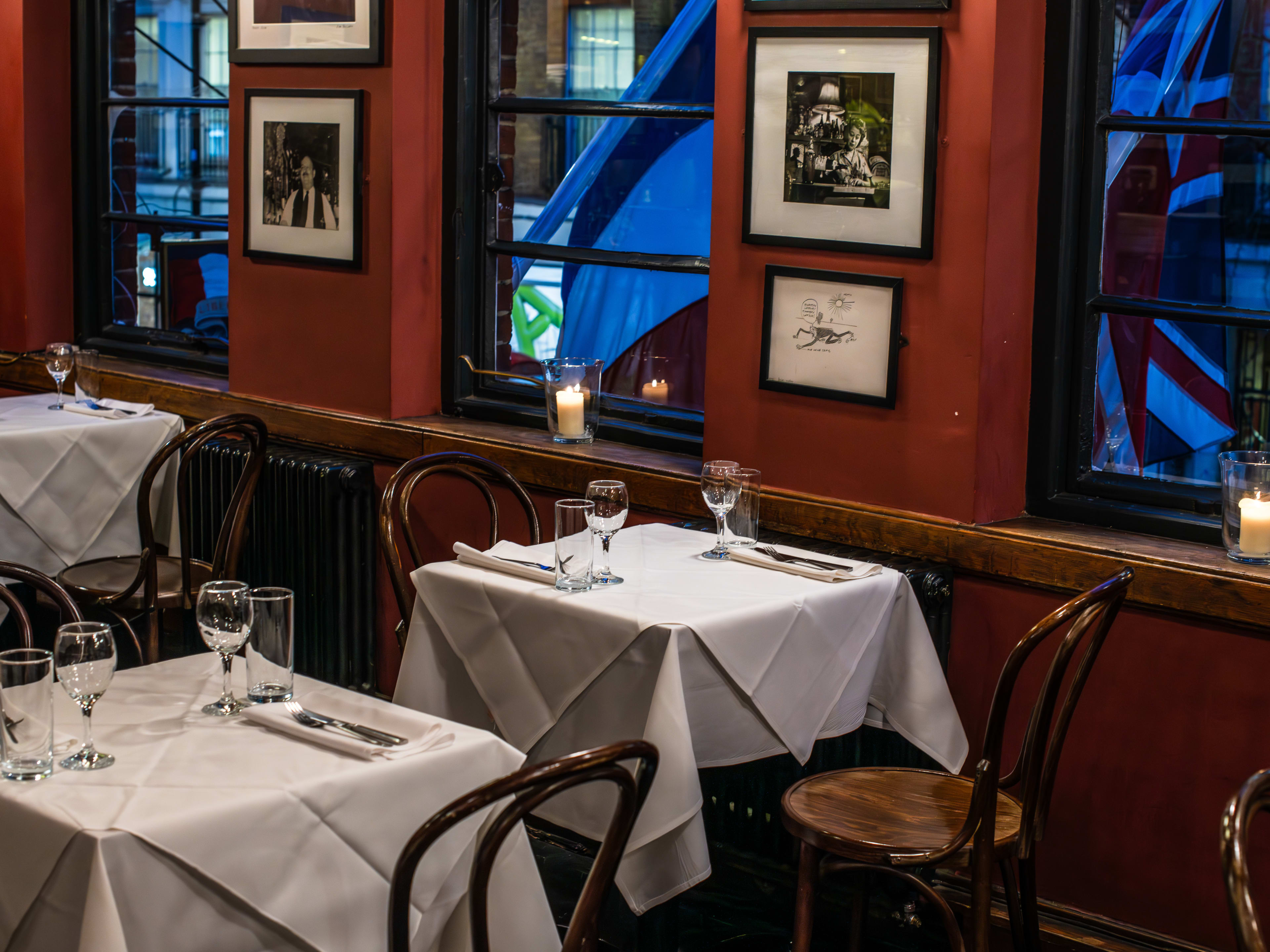 The red-walled and white table-clothed upstairs dining room of The French House.