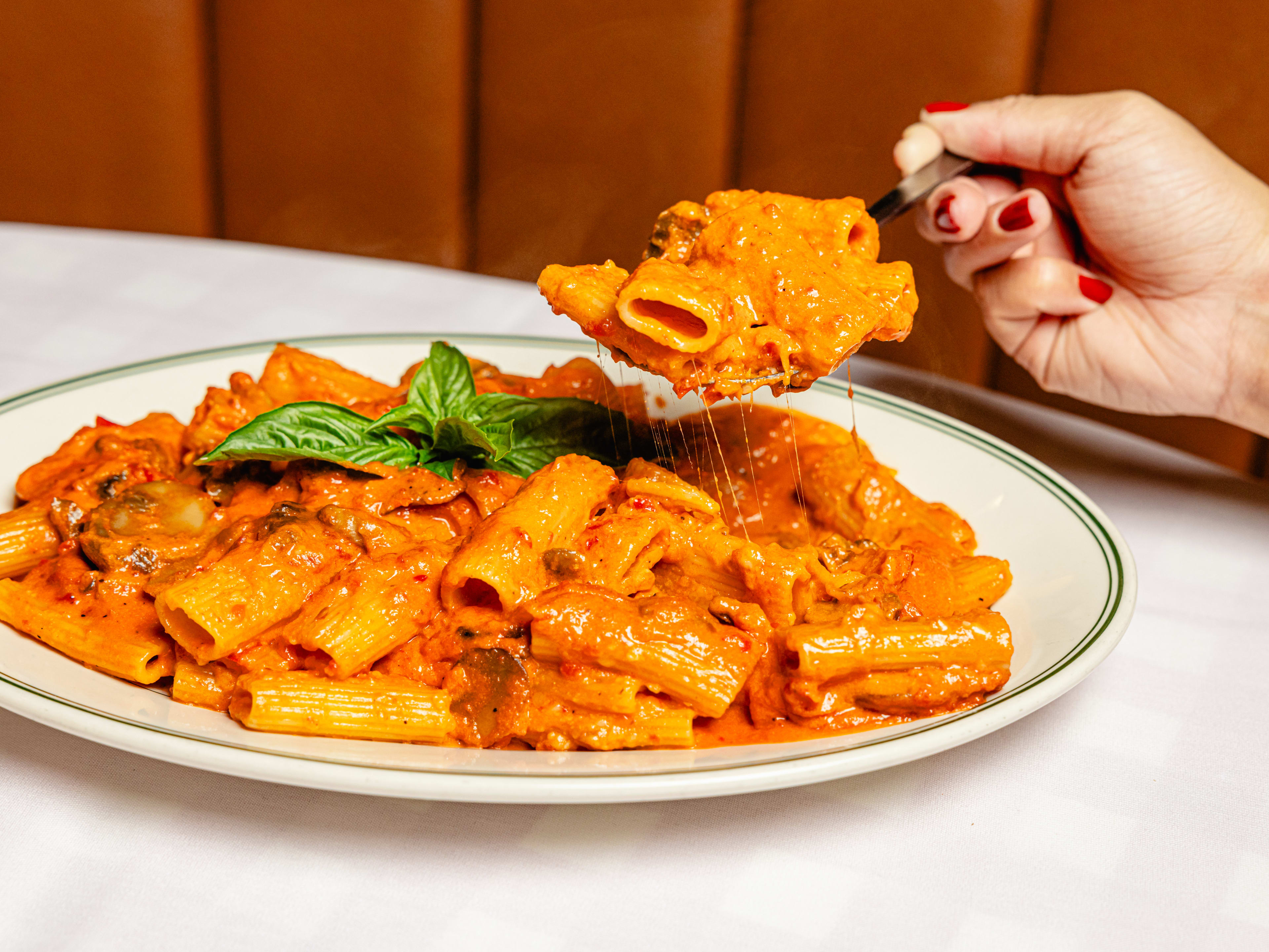 A very large portion of rigatoni covered in a creamy, bright orange vodka sauce.