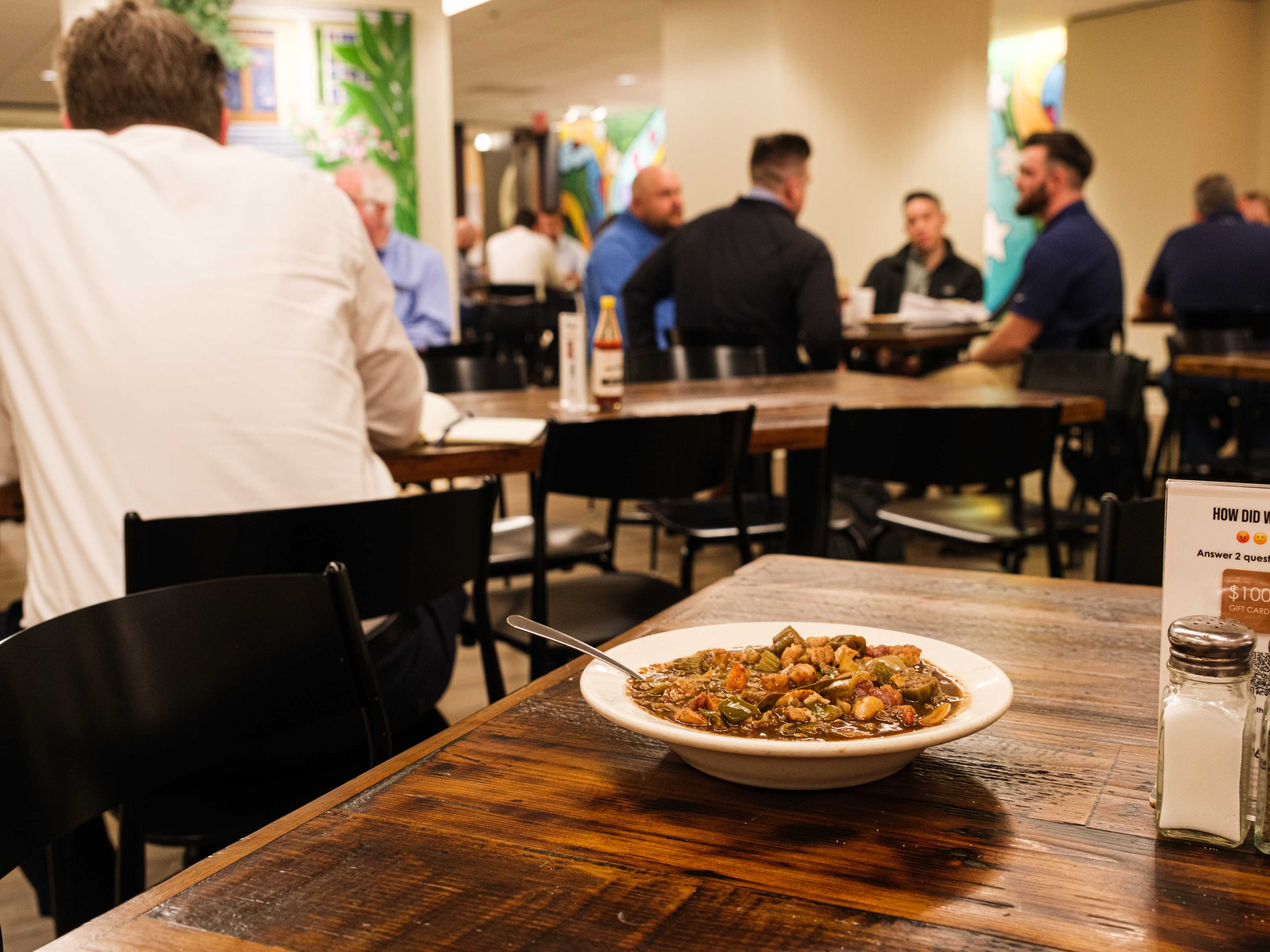 A bowl of gumbo on a table and people eating at other tables at Treebeards.