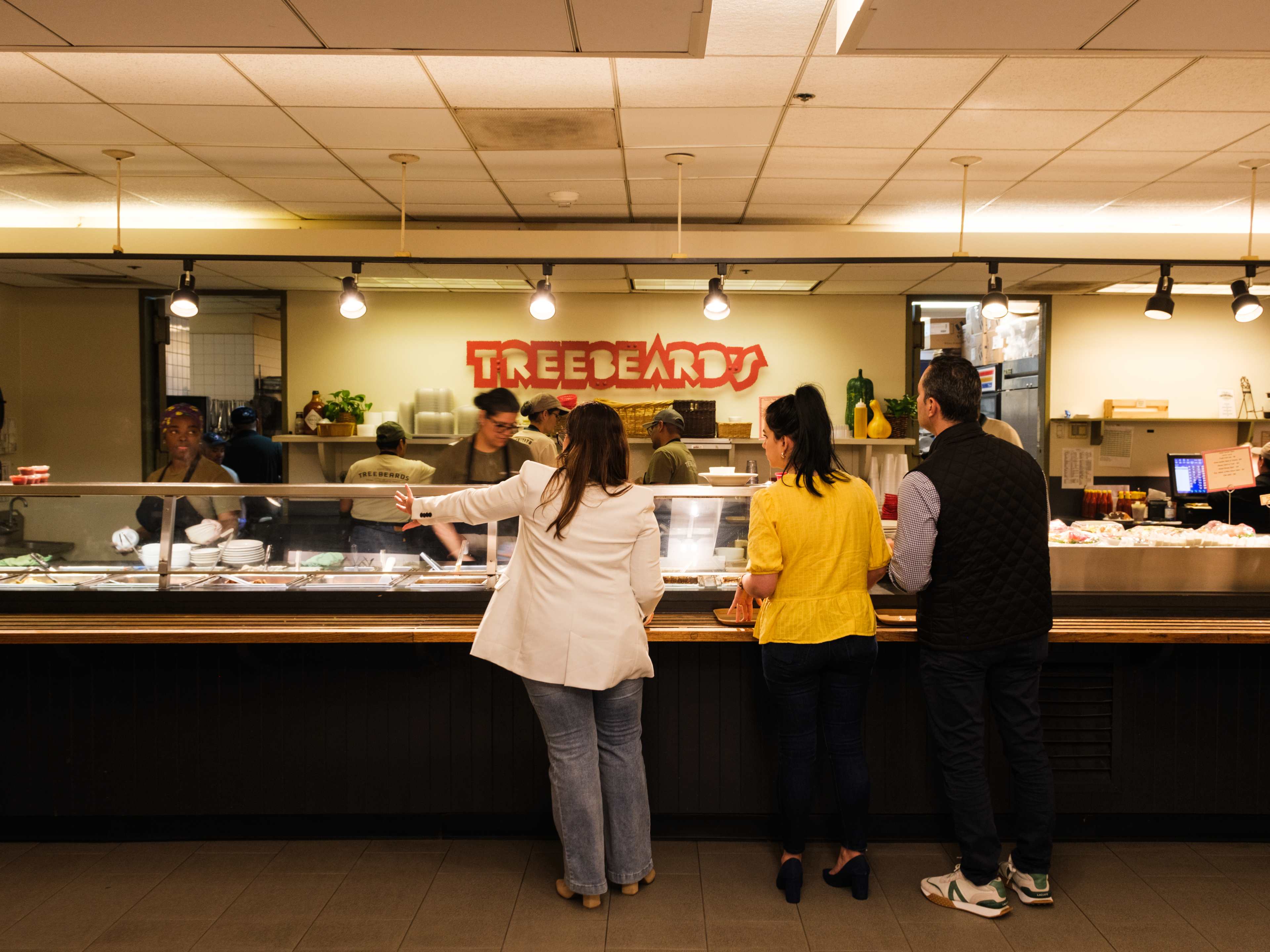 People browsing the food counter at Treebeards.