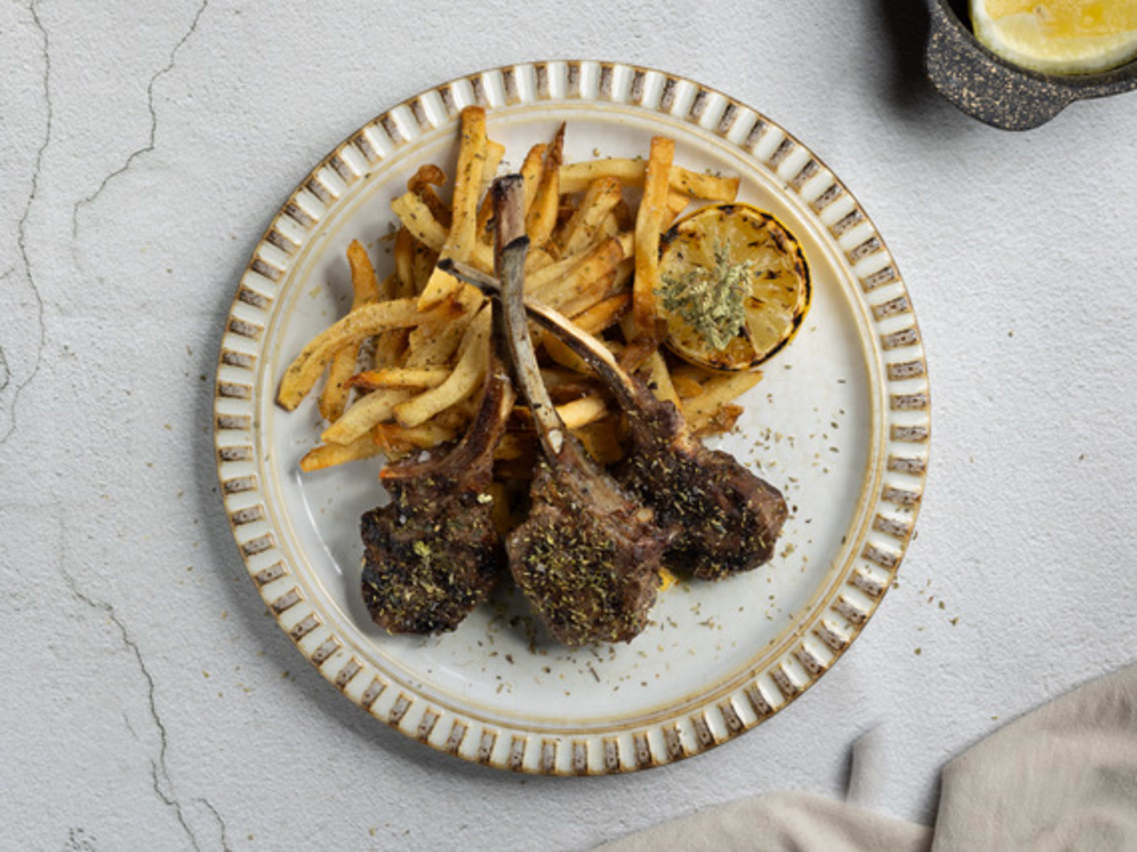 Lamb chops with fries on a plate.