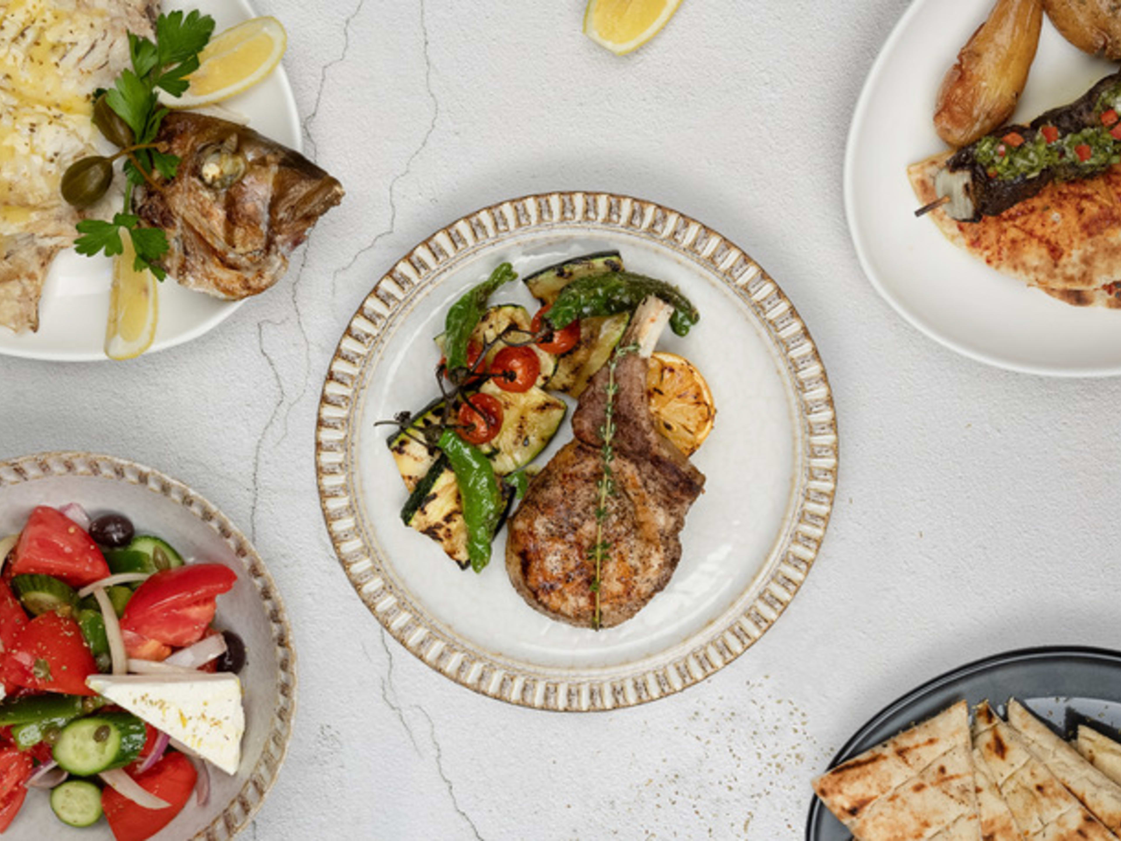 A table covered in Greek food.